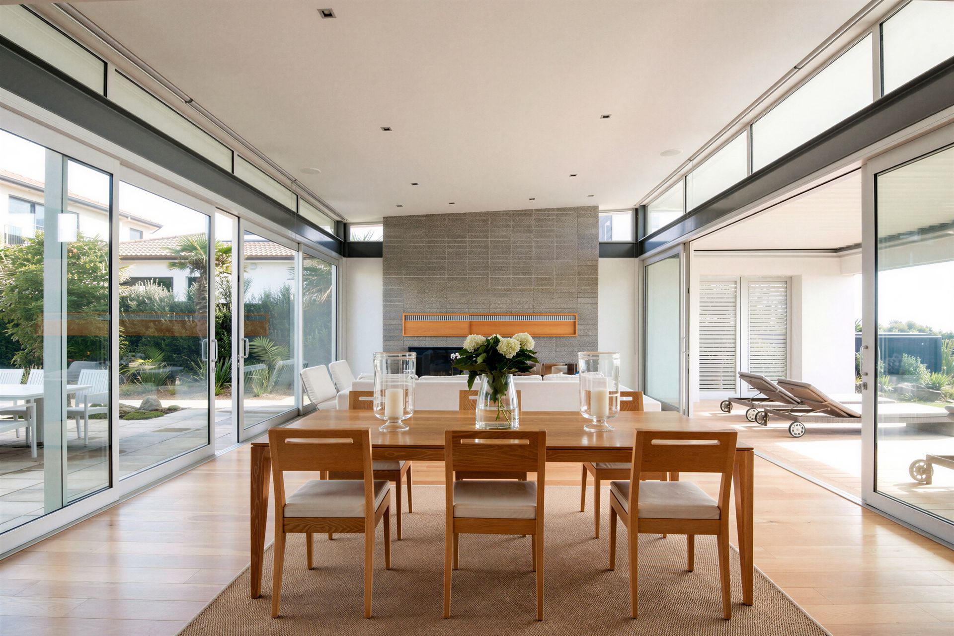 From the oak dining table, views extend towards the living room and its substantial built-in fireplace. Large sliding doors open to both the beachfront deck and the sheltered courtyard, allowing the open-plan space to connect effortlessly with the outdoors.