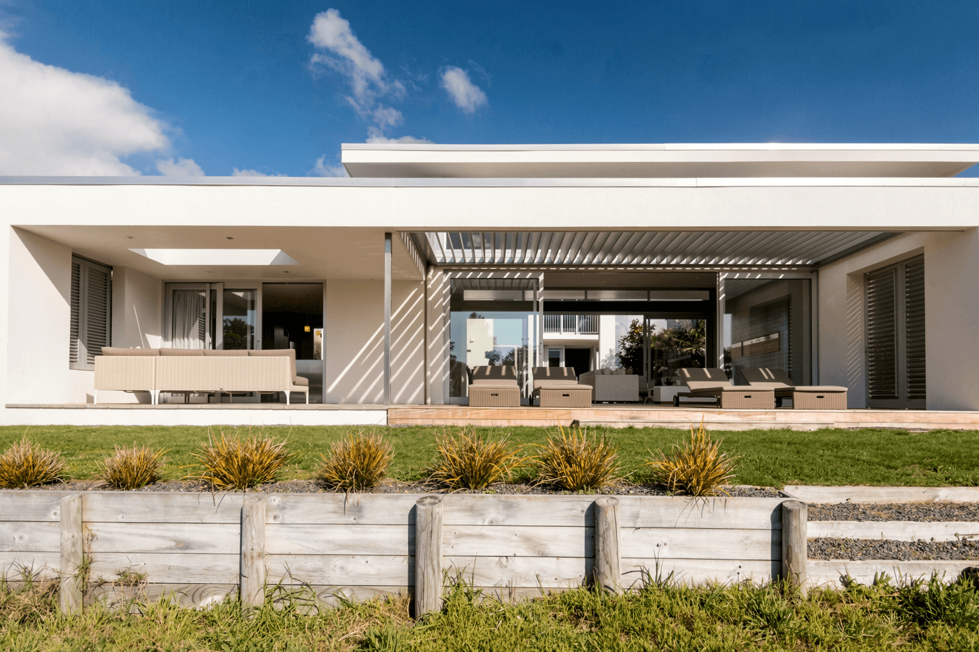 The beachfront elevation is designed to open fully to its coastal setting. A generous lawn, sheltered deck and expansive sliding doors create a seamless sequence from the sand dunes through the open-plan living spaces to the internal courtyard.
