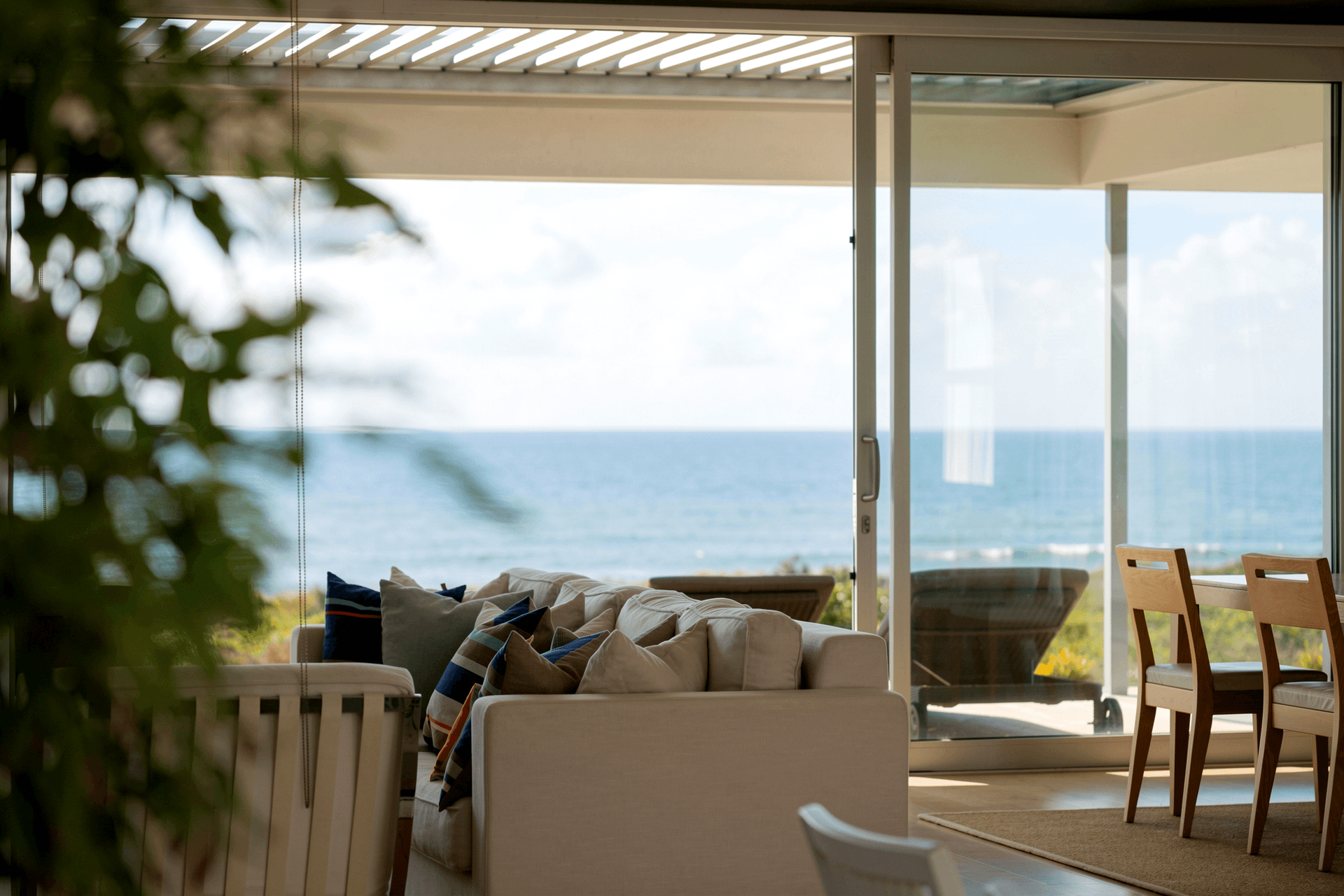 From the internal courtyard, views extend through the living and dining spaces to the covered beachfront deck and sea beyond. This strong visual connection brings light and landscape into the centre of the home while linking its sheltered and coastal outdoor spaces.