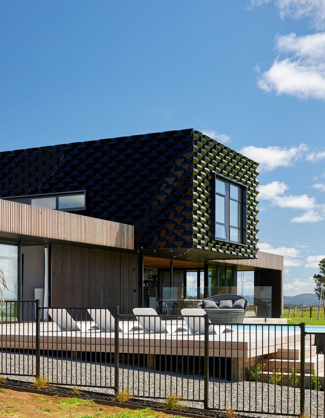 Metal 'scales' were developed to act as a solar shield for the upper level and to create contrast against the natural look of the larch cladding on the lower level.