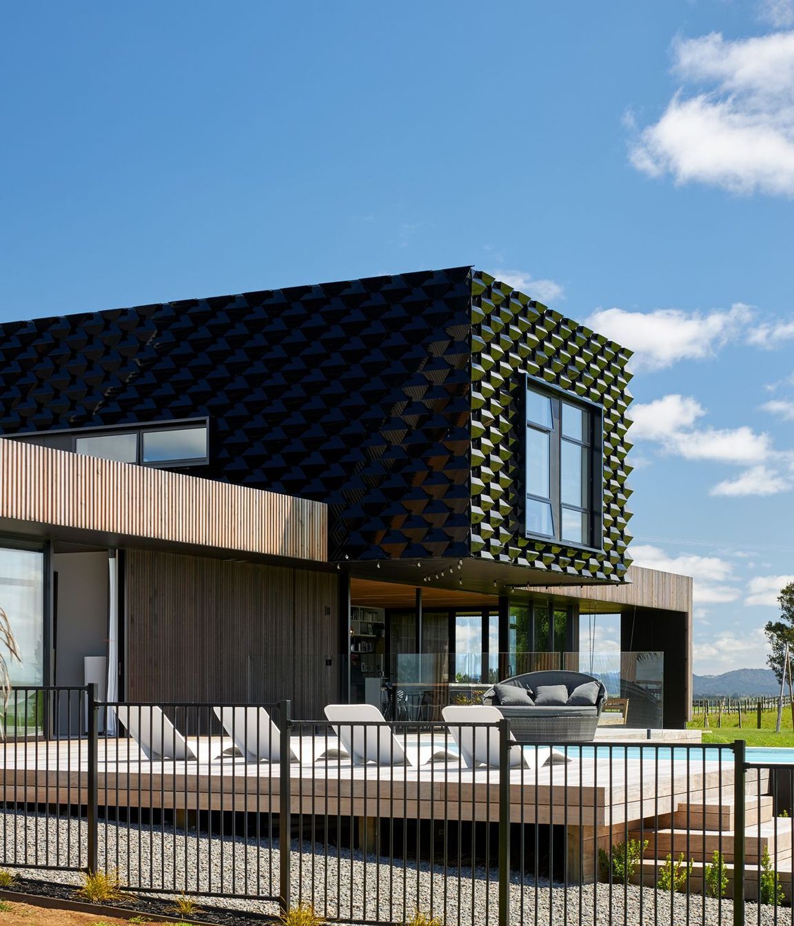 Metal 'scales' were developed to act as a solar shield for the upper level and to create contrast against the natural look of the larch cladding on the lower level.