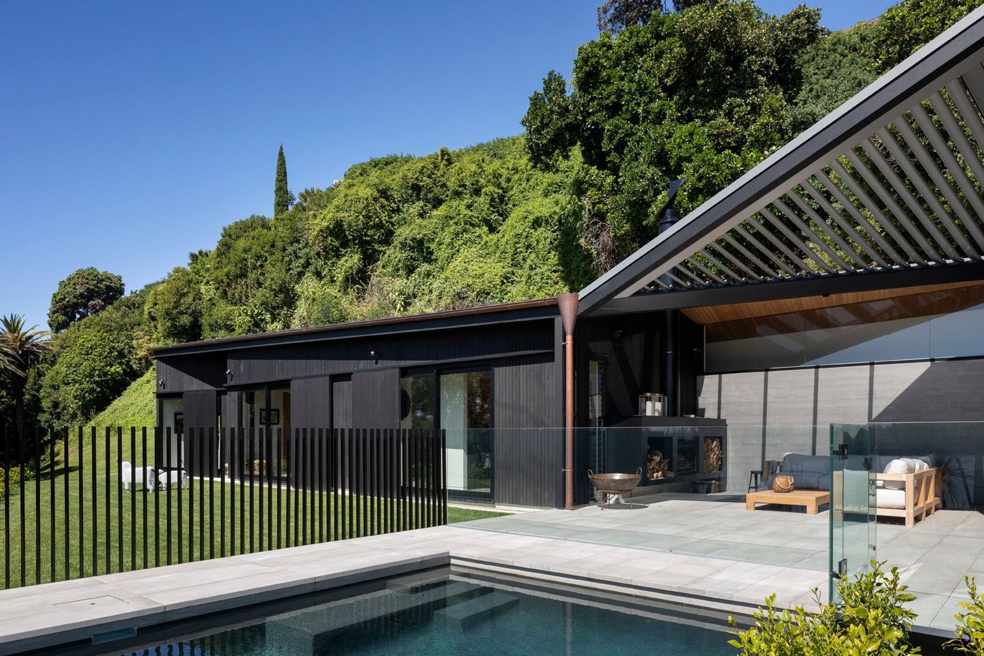 A single-storey form—which contains a family room and guest bedrooms—pulls away from the main house allowing for the insertion of a glazed and louvered outdoor room, centred on the swimming pool.