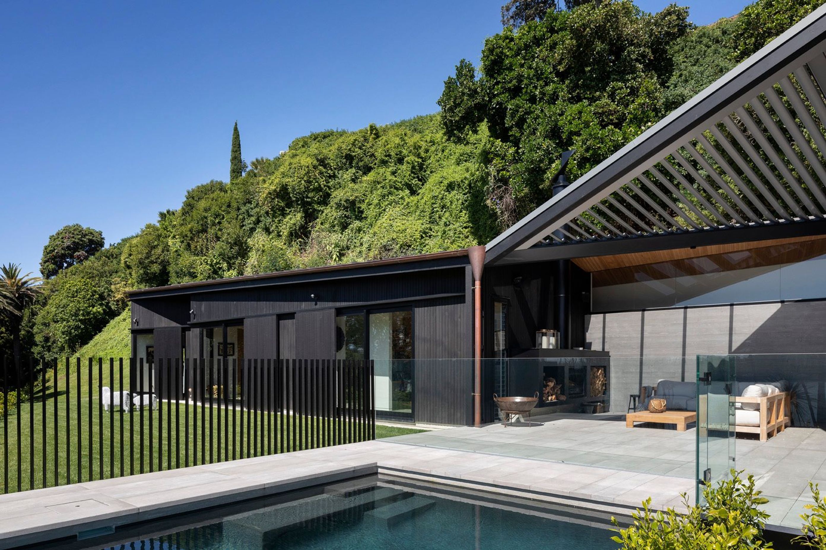 A single-storey form—which contains a family room and guest bedrooms—pulls away from the main house allowing for the insertion of a glazed and louvered outdoor room, centred on the swimming pool.