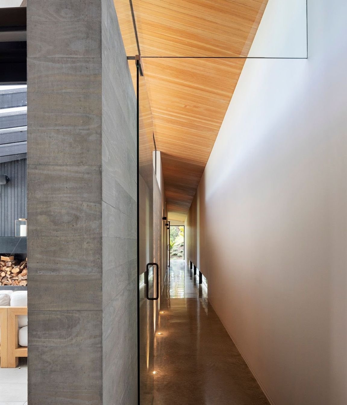 A  long corridor, which features a polished concrete floor and insitu concrete wall, leads from the dining room to the guest bedrooms and family room at the northern end of the house.
