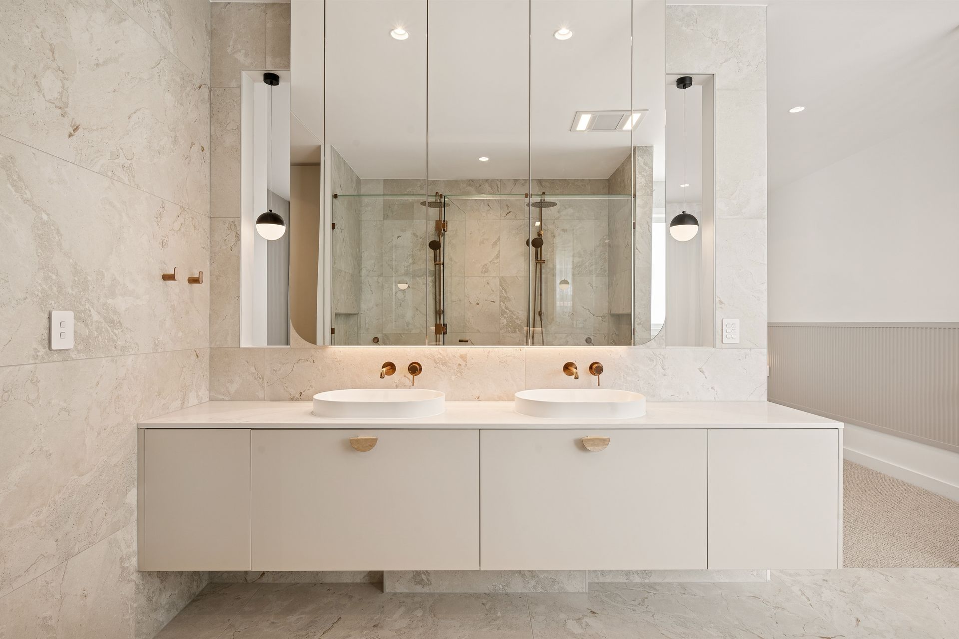 Timber-lined drawers and half-round handles run the length of the walk-in robe.