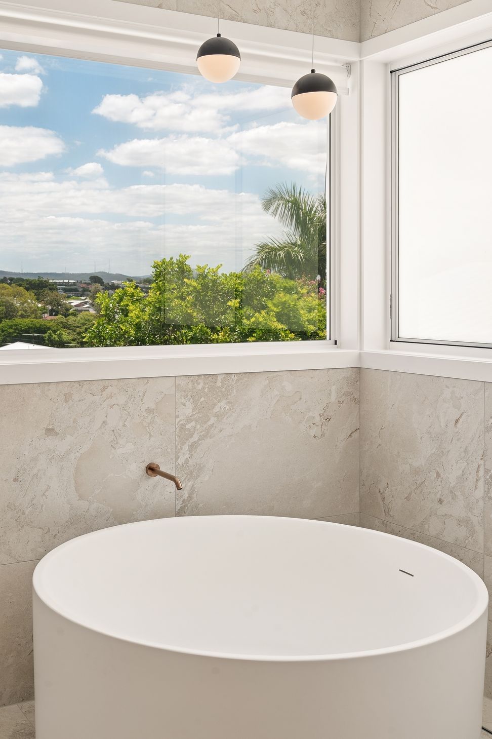 The scullery's servery window opens straight onto the courtyard, brass tapware catching the light.