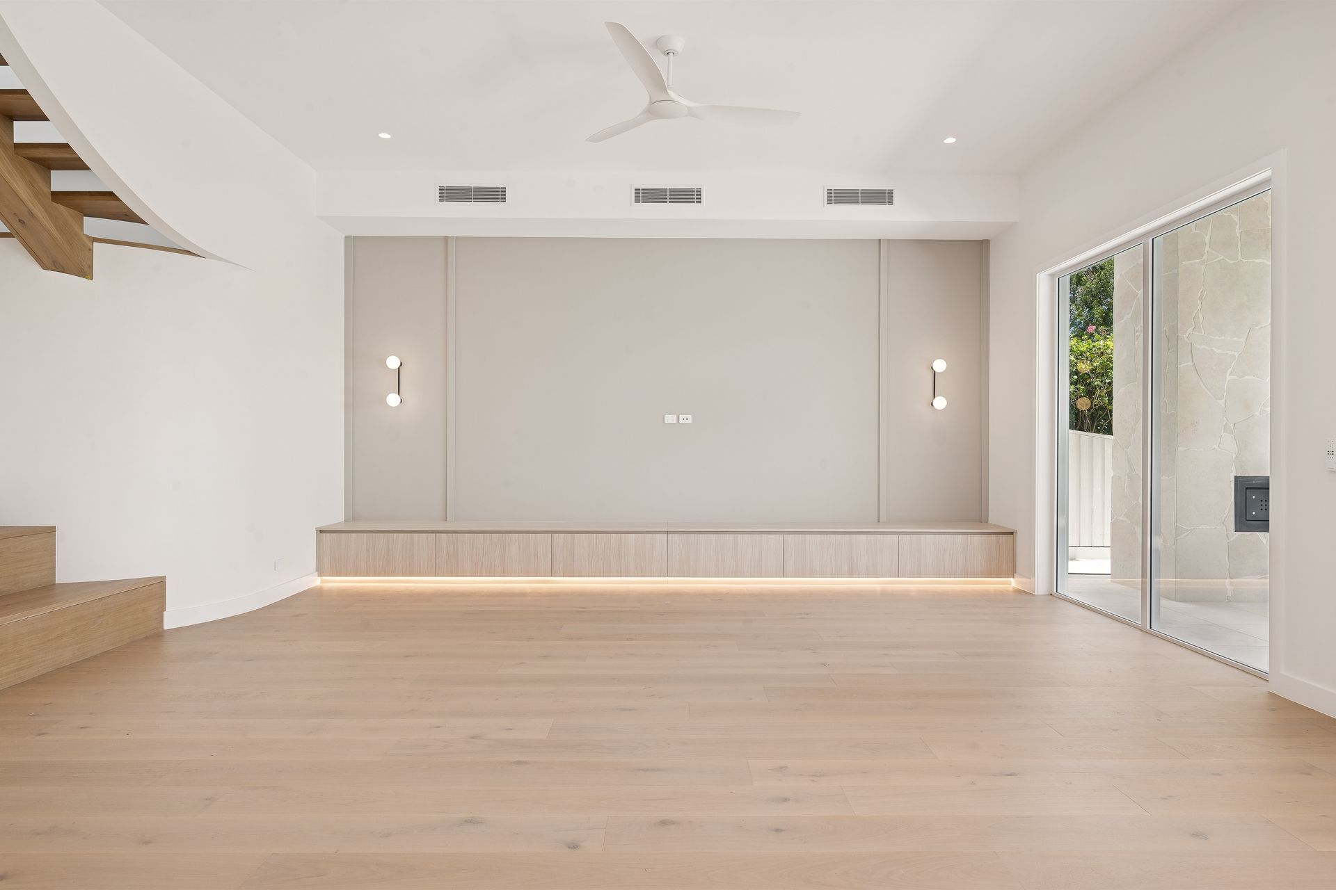 The living room opens directly onto a curved stair and an indoor garden bed.