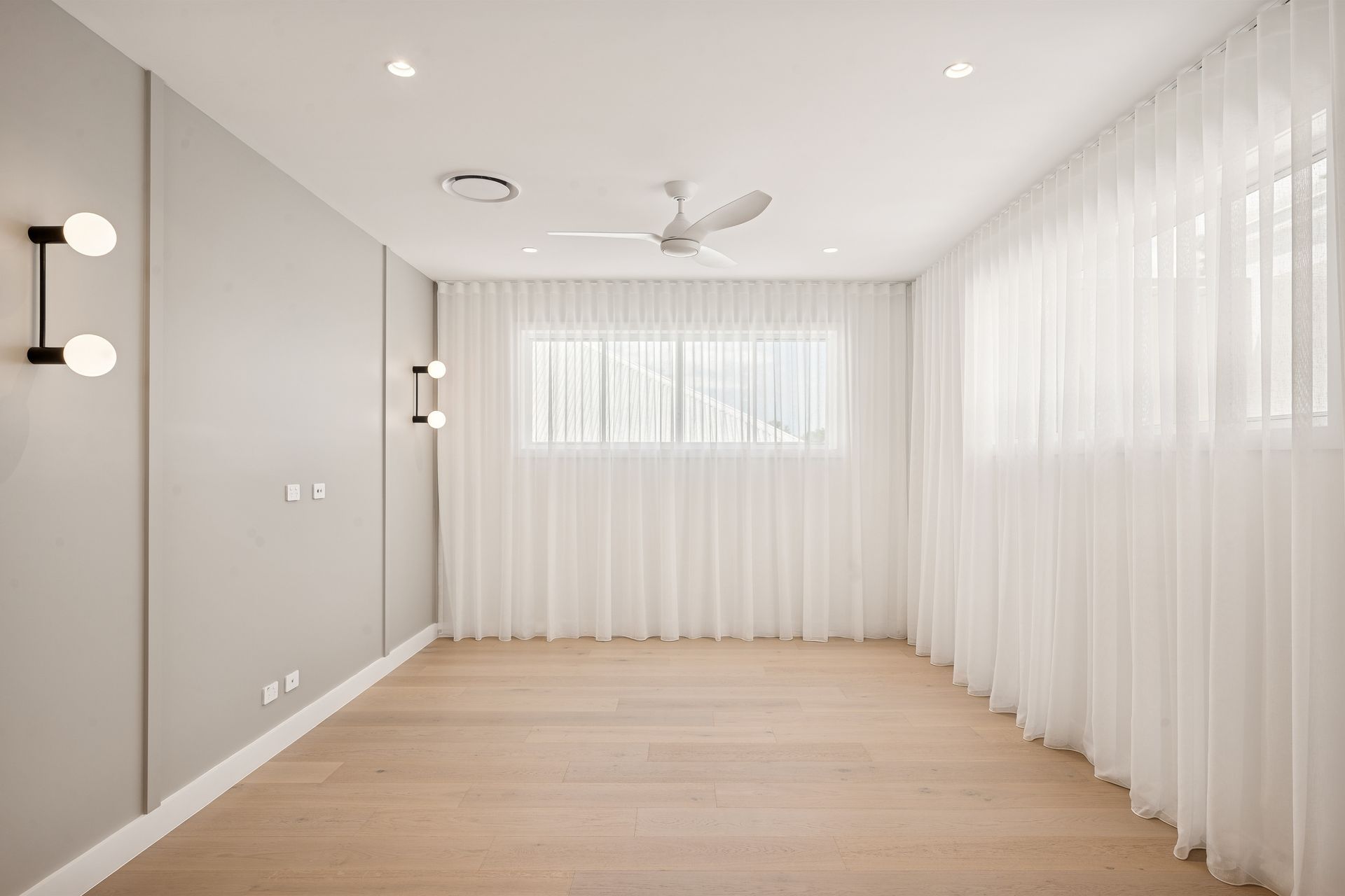 Fluted panelling forms a soft headboard wall, opening directly to the ensuite beyond.