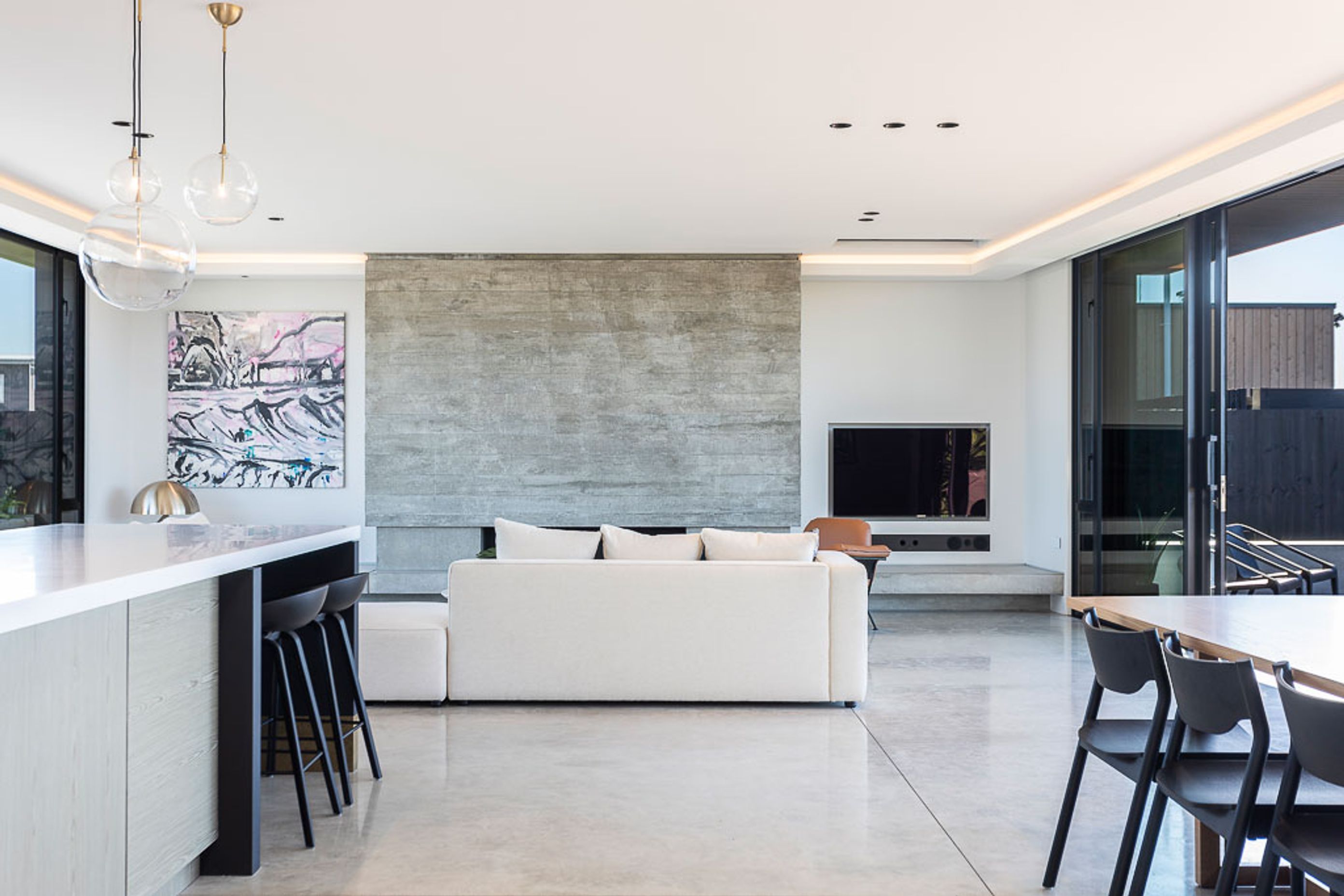 The main living space features extensive glazing and outdoor spaces on both sides.