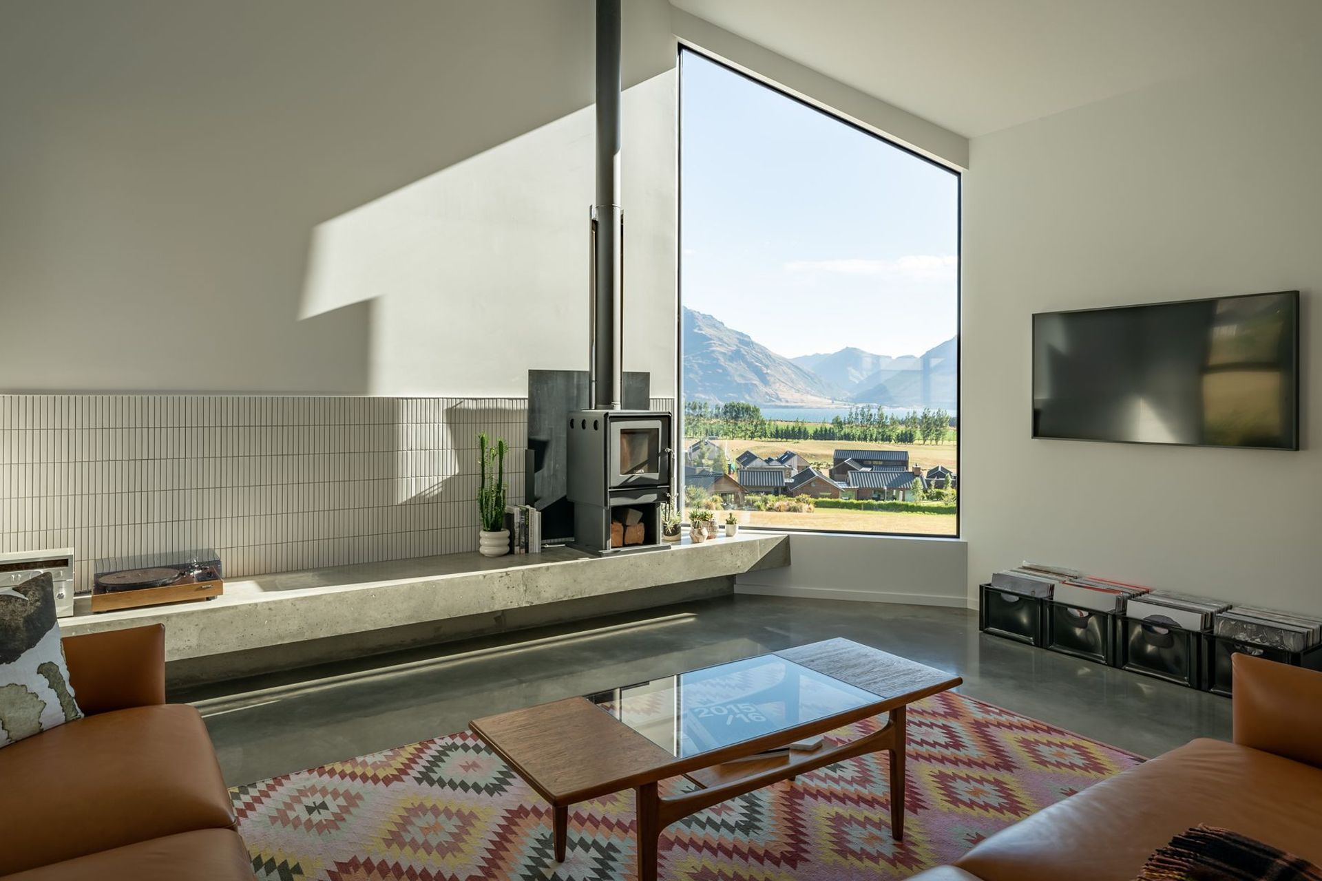 The sunken lounge with woodburner includes a built-in concrete display bench that showcases the homeowner's unique objects.