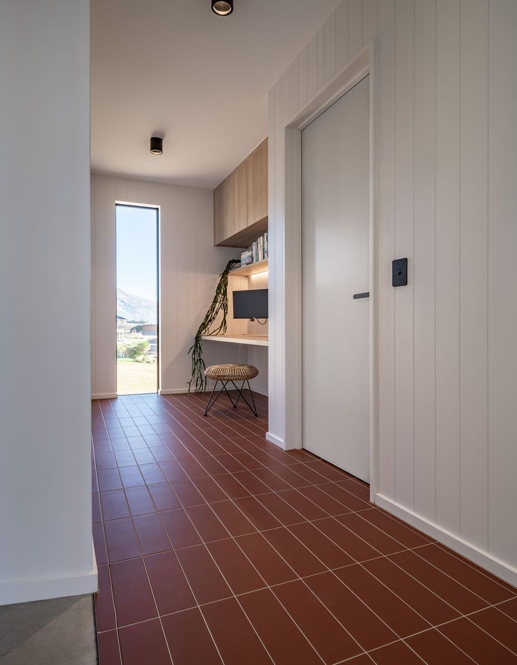 The entryway with terracotta tiles and built-in study for adults.