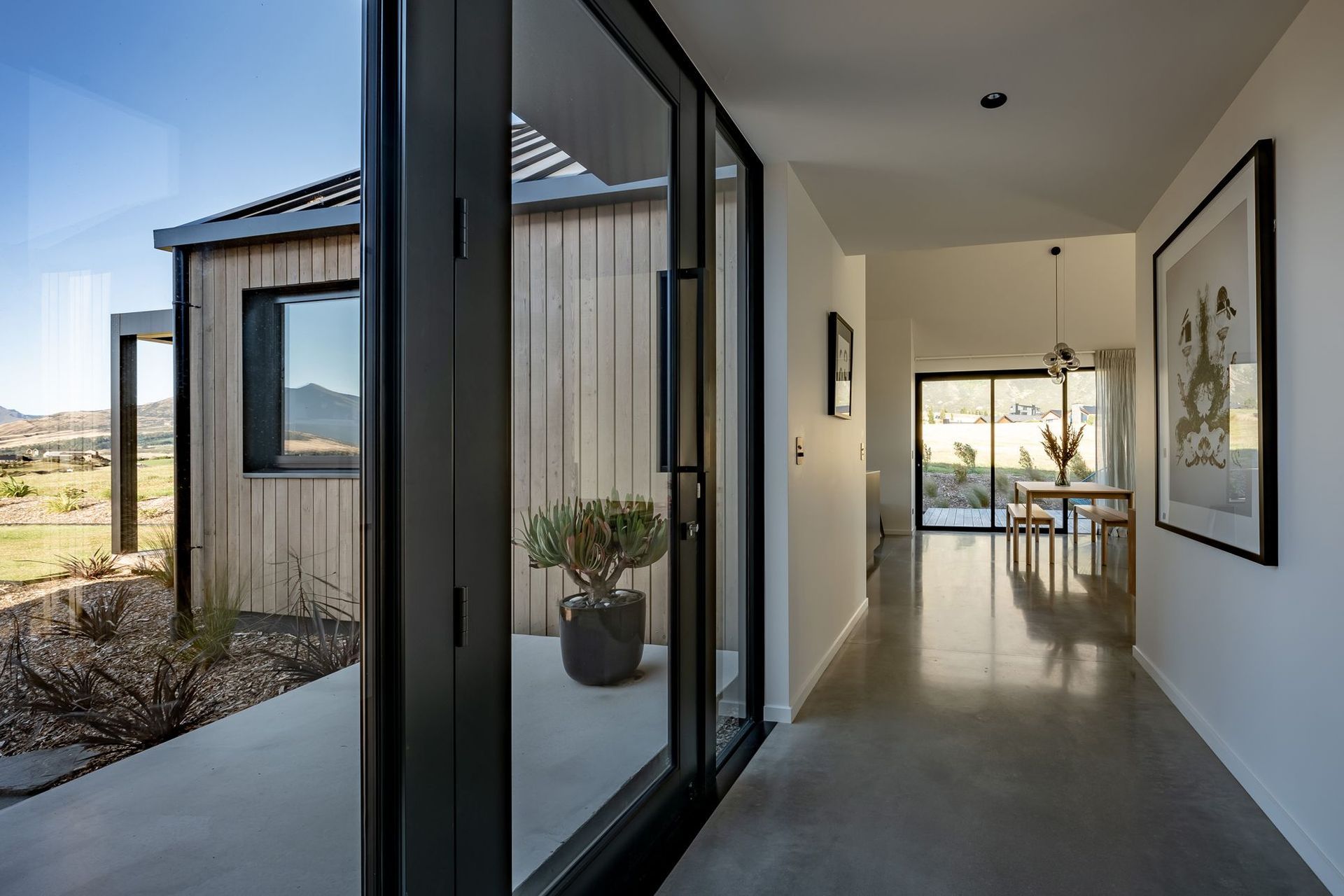 The glazed hallway to the living space provides a gallery wall for the homeowner's art collection on one side.