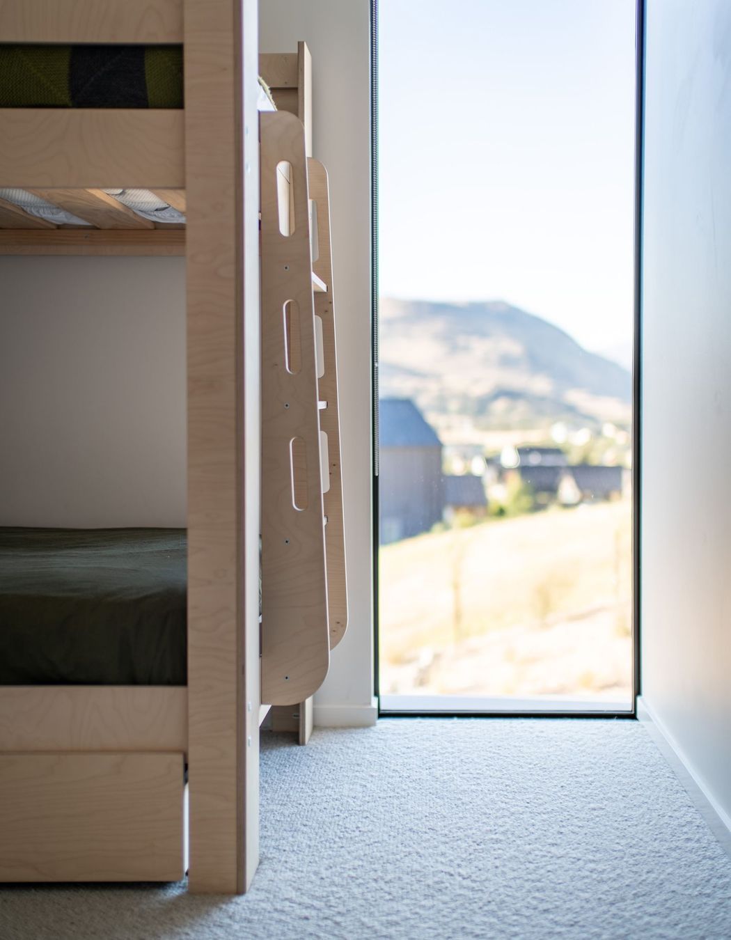 A child's bedroom features a slot window to take in light and scenery.