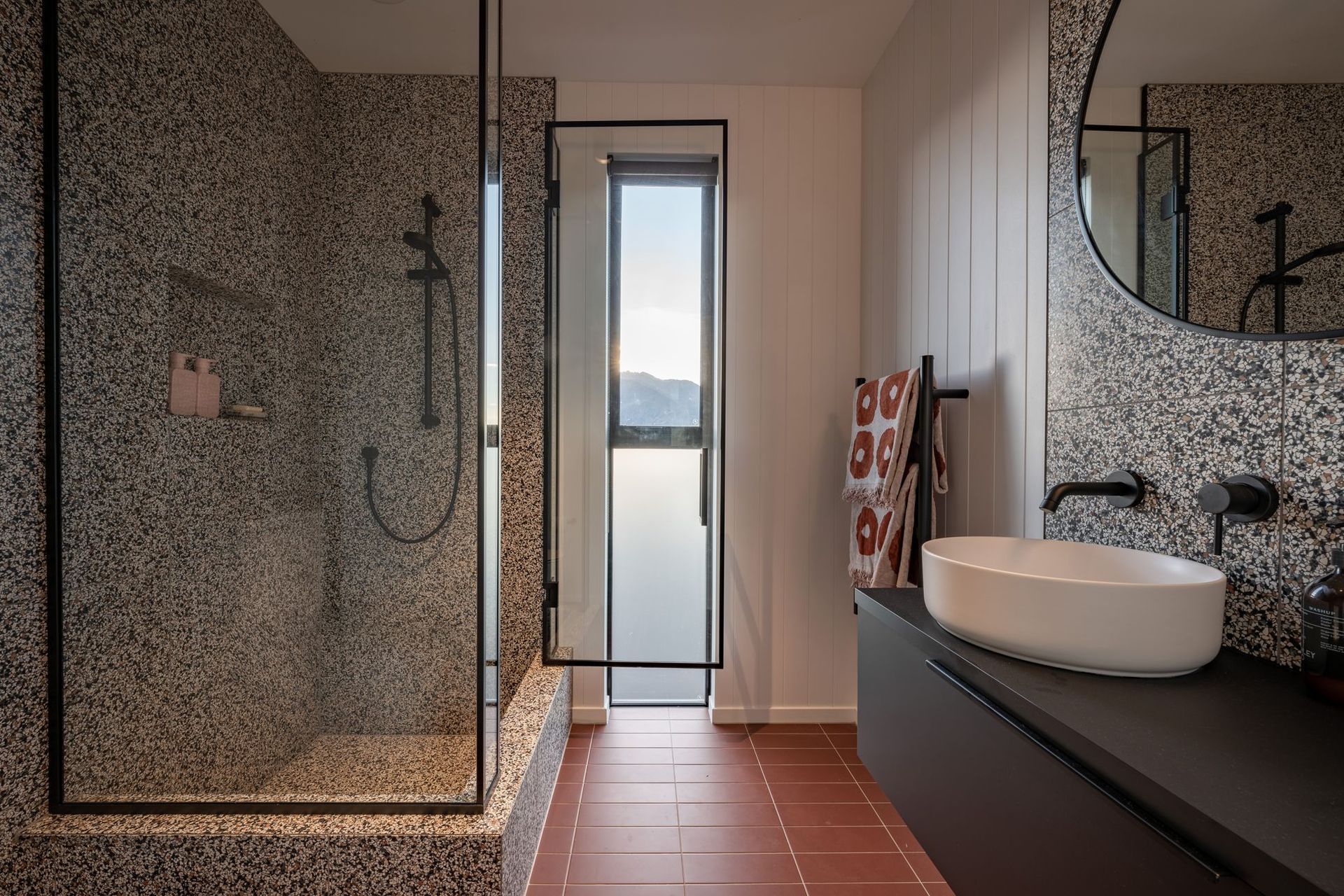 The family bathroom is far more playful, with terracotta floors, and speckled tiles, with a shub built into the shower.