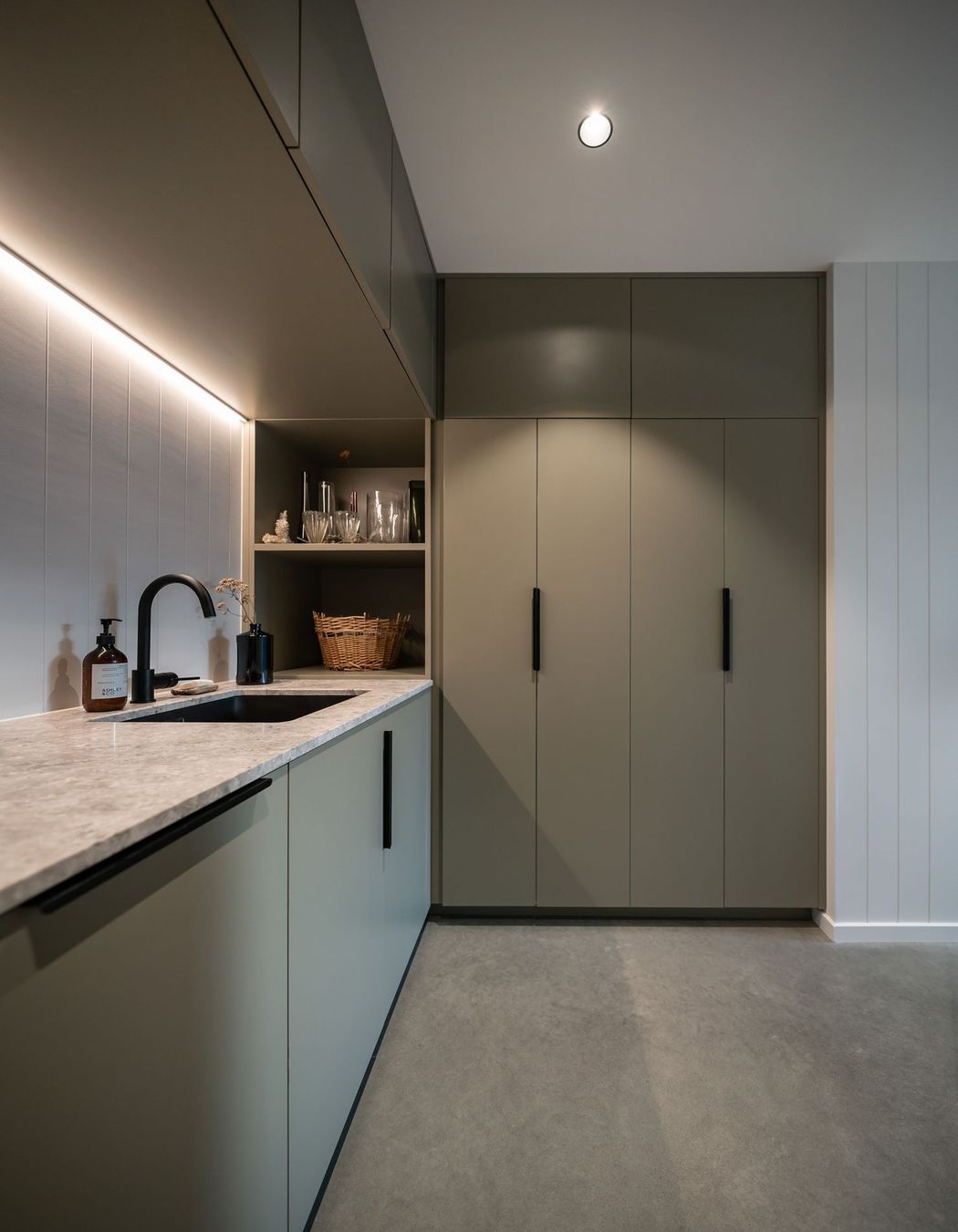 The laundry takes in more subdued hues for a relaxing utility space.