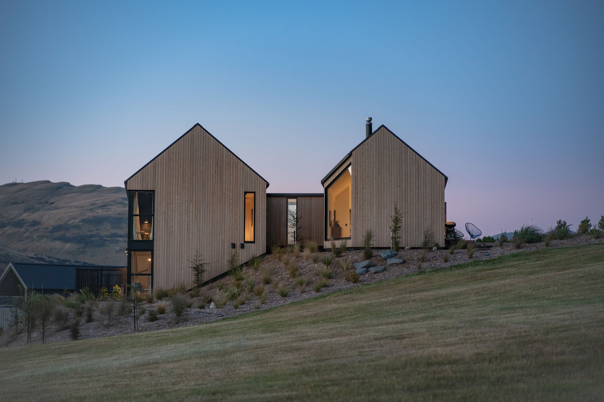 The slot window at the end of the entry hallway can be seen at the right side of the two-storey gable form.