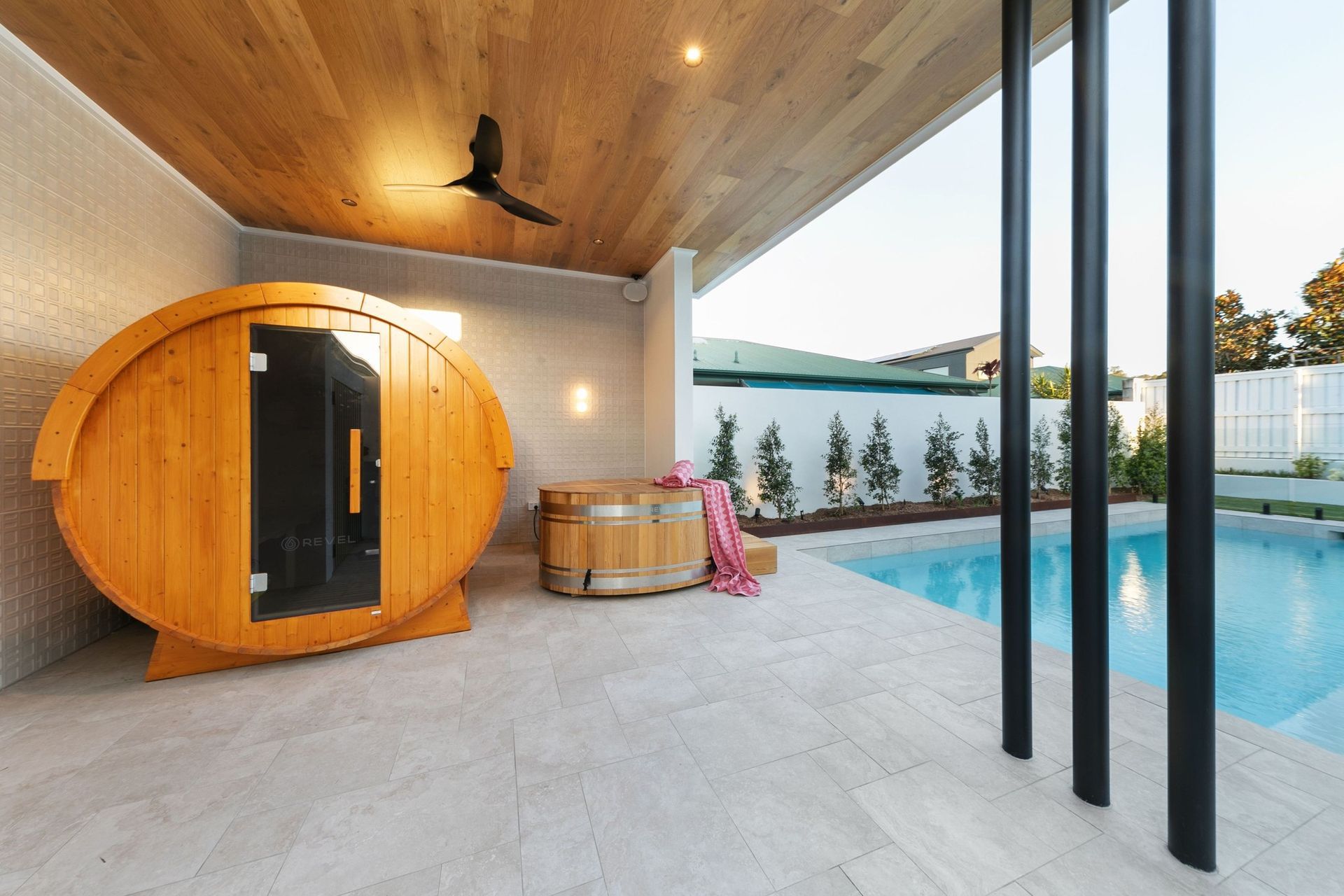 Sauna and cold plunge sit under cover beside the pool — wellness built into the everyday.