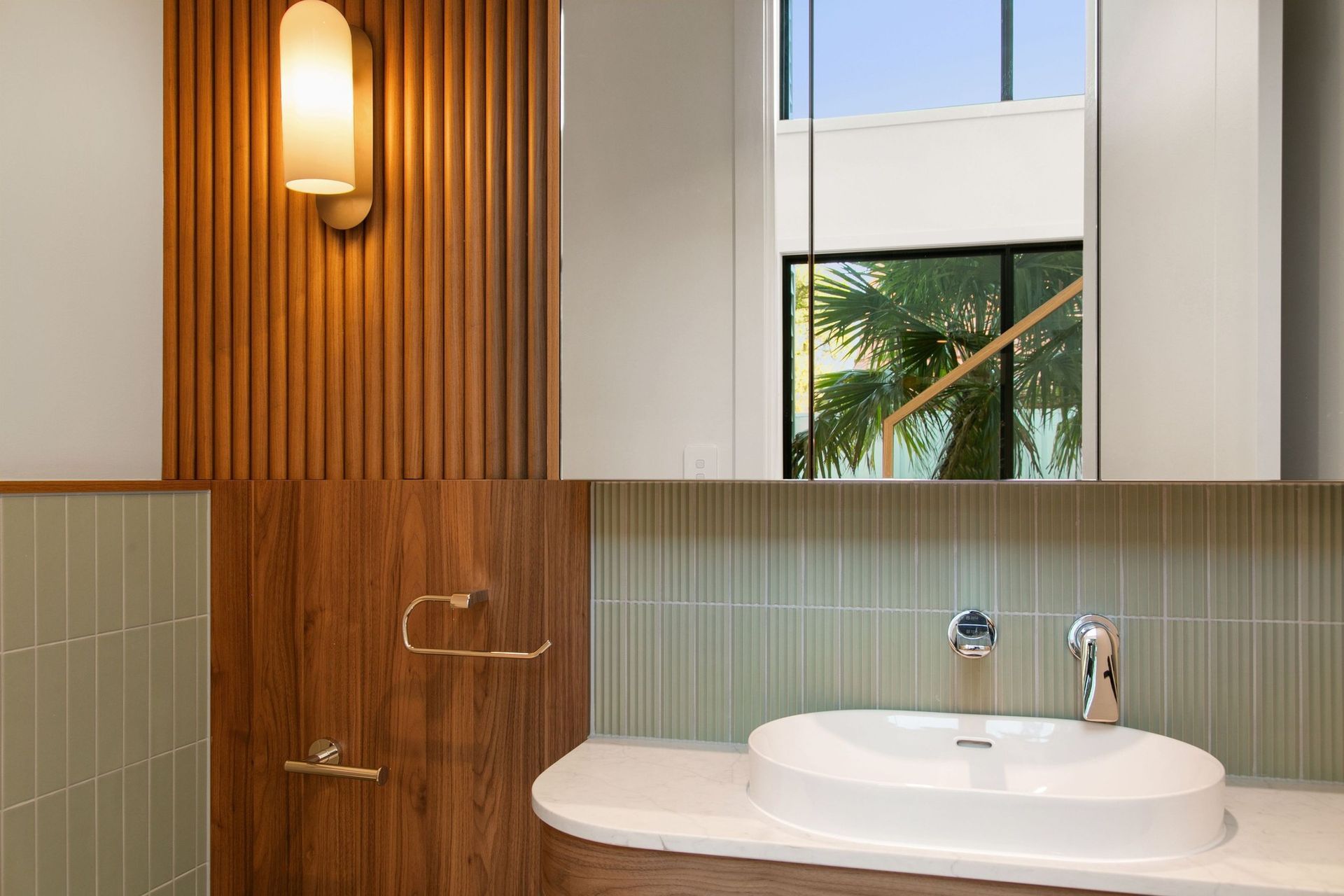 Walnut and sage carry the home's mid-century thread into the bathrooms.