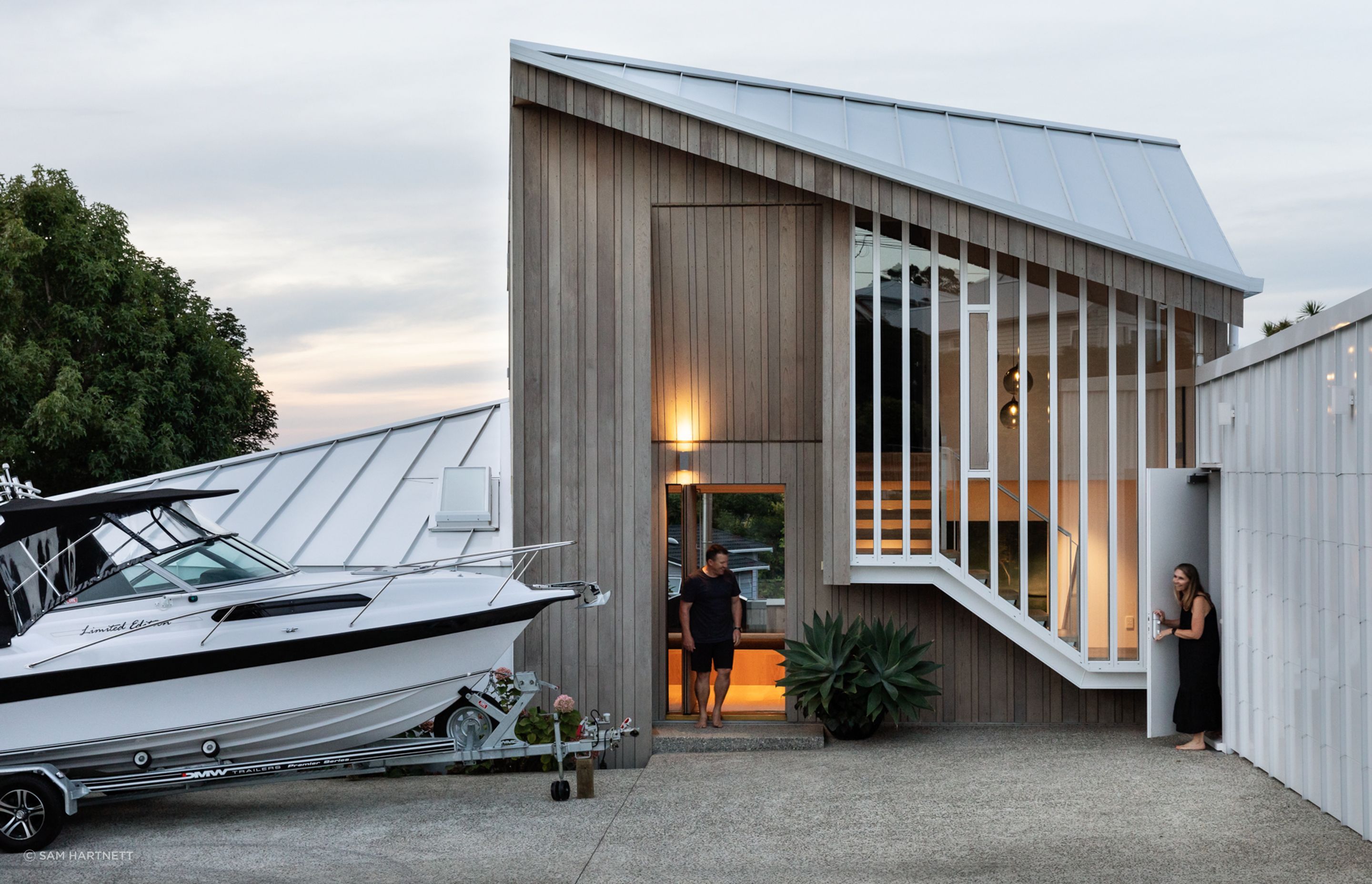 Hints of the domestic are offered via a cedar clad entry, with tall slender windows looking outwards.