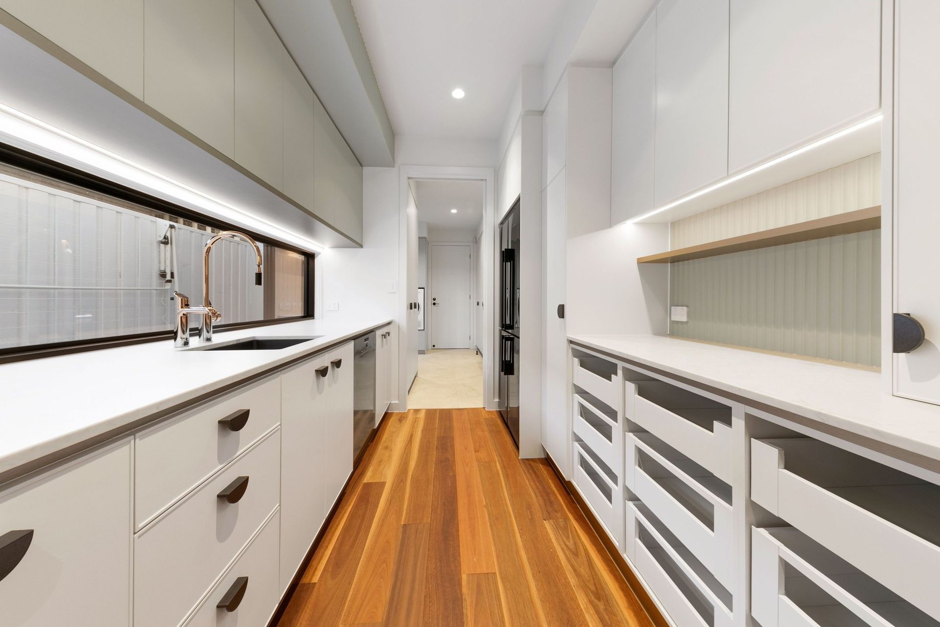 A full butler's pantry keeps the main kitchen calm — storage, prep and second sink out of sight.