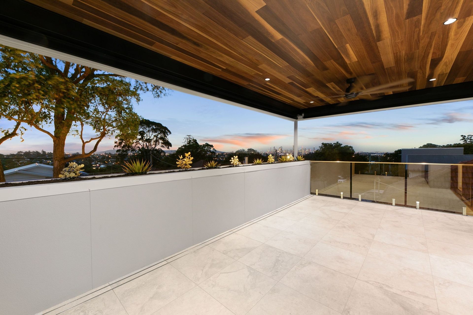 From the upper balcony, the skyline reads over the treetops — the payoff of a hilltop street.