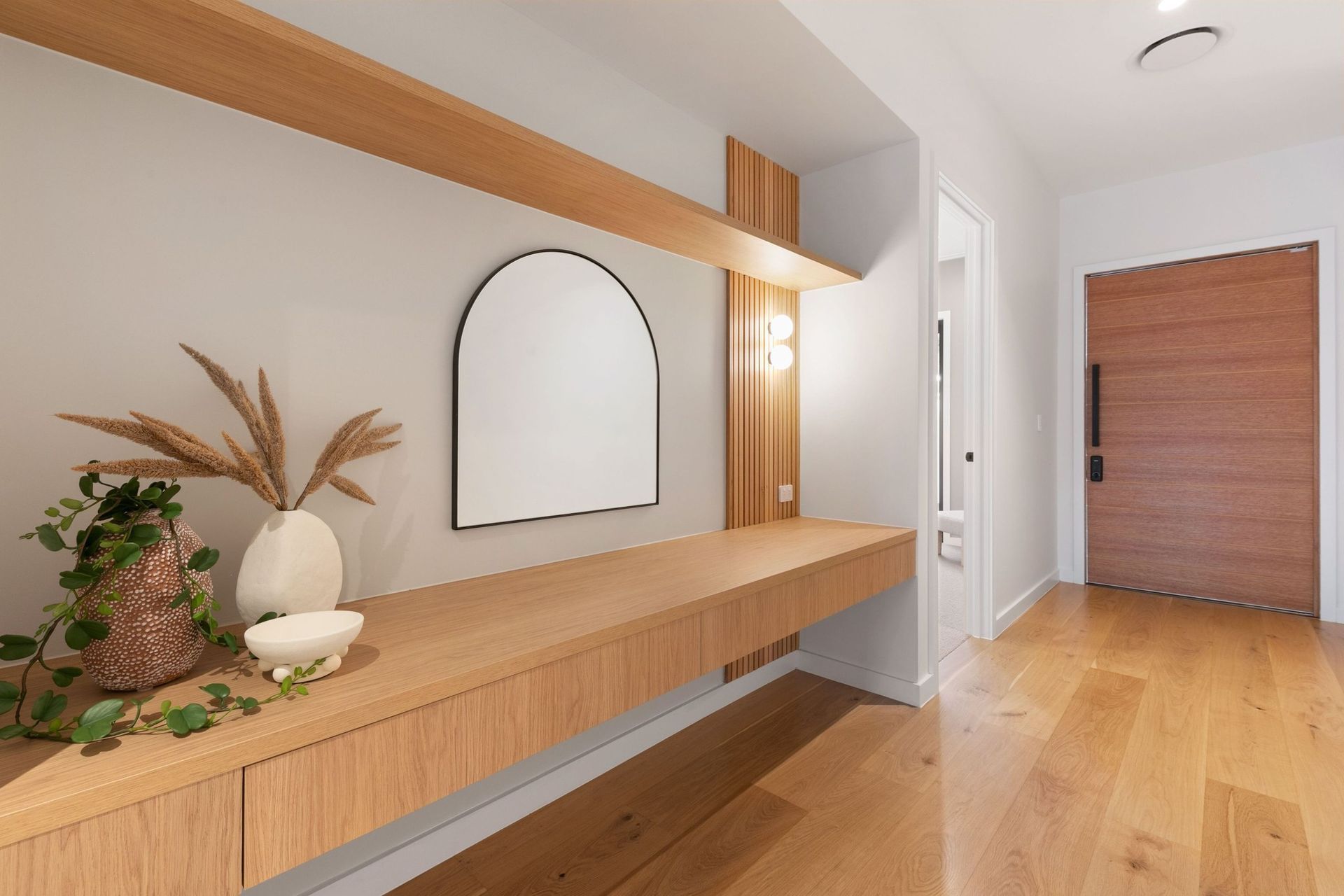 Oak, fluting and an arched mirror set the tone from the moment the door opens.