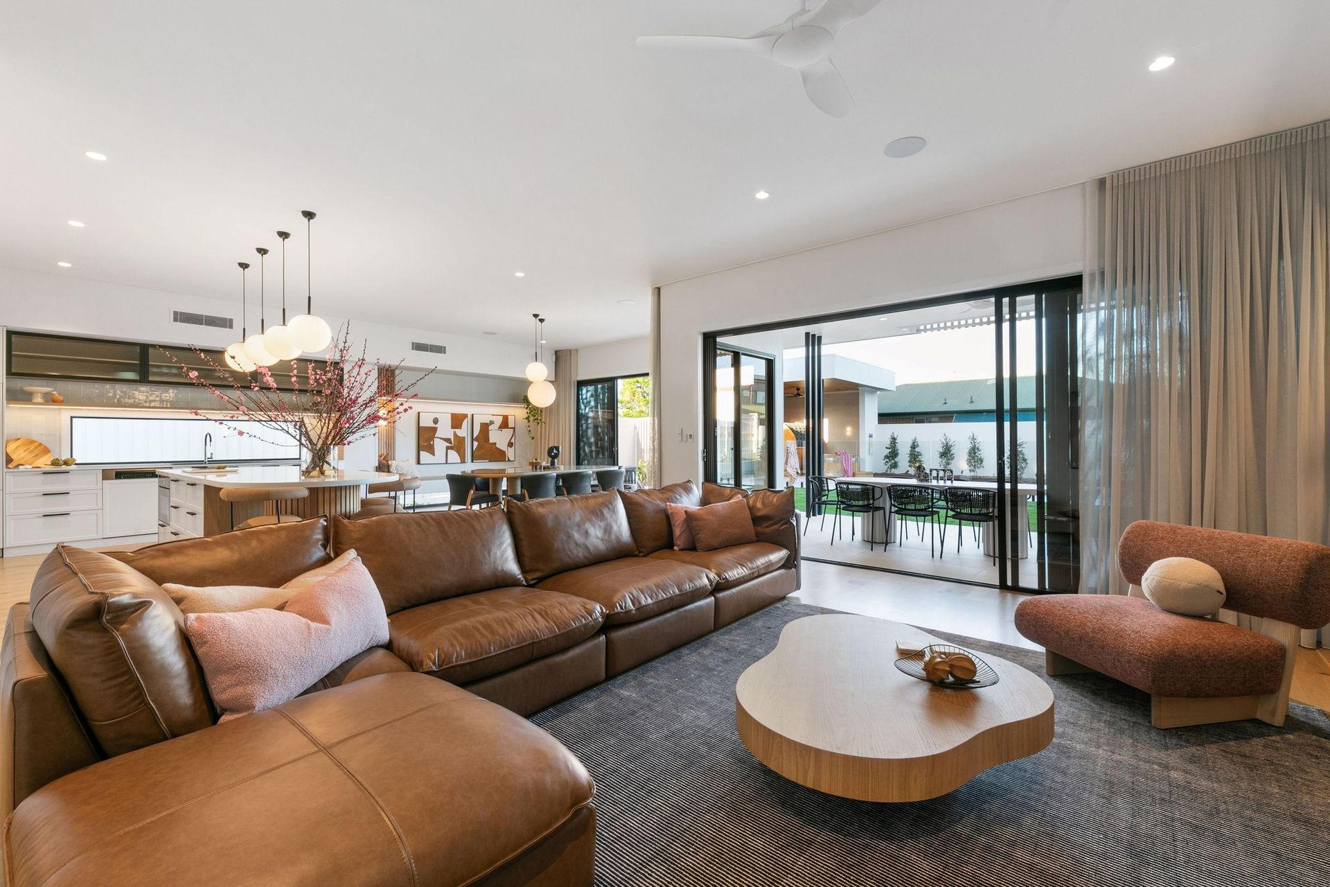The living room hands off to the alfresco through a full wall of glass.