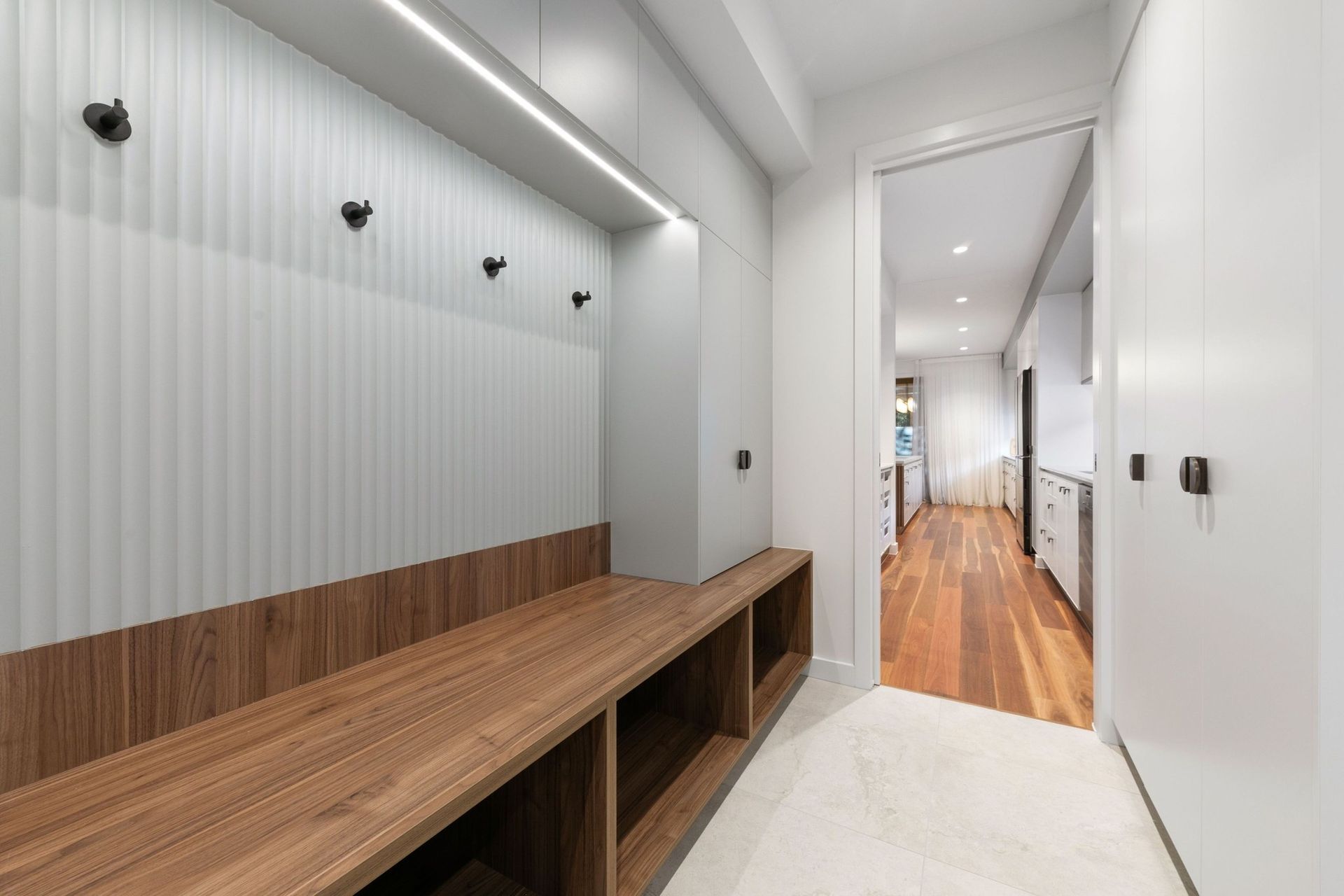 The mudroom brings order to everyday comings and goings, in walnut and fluted panelling.
