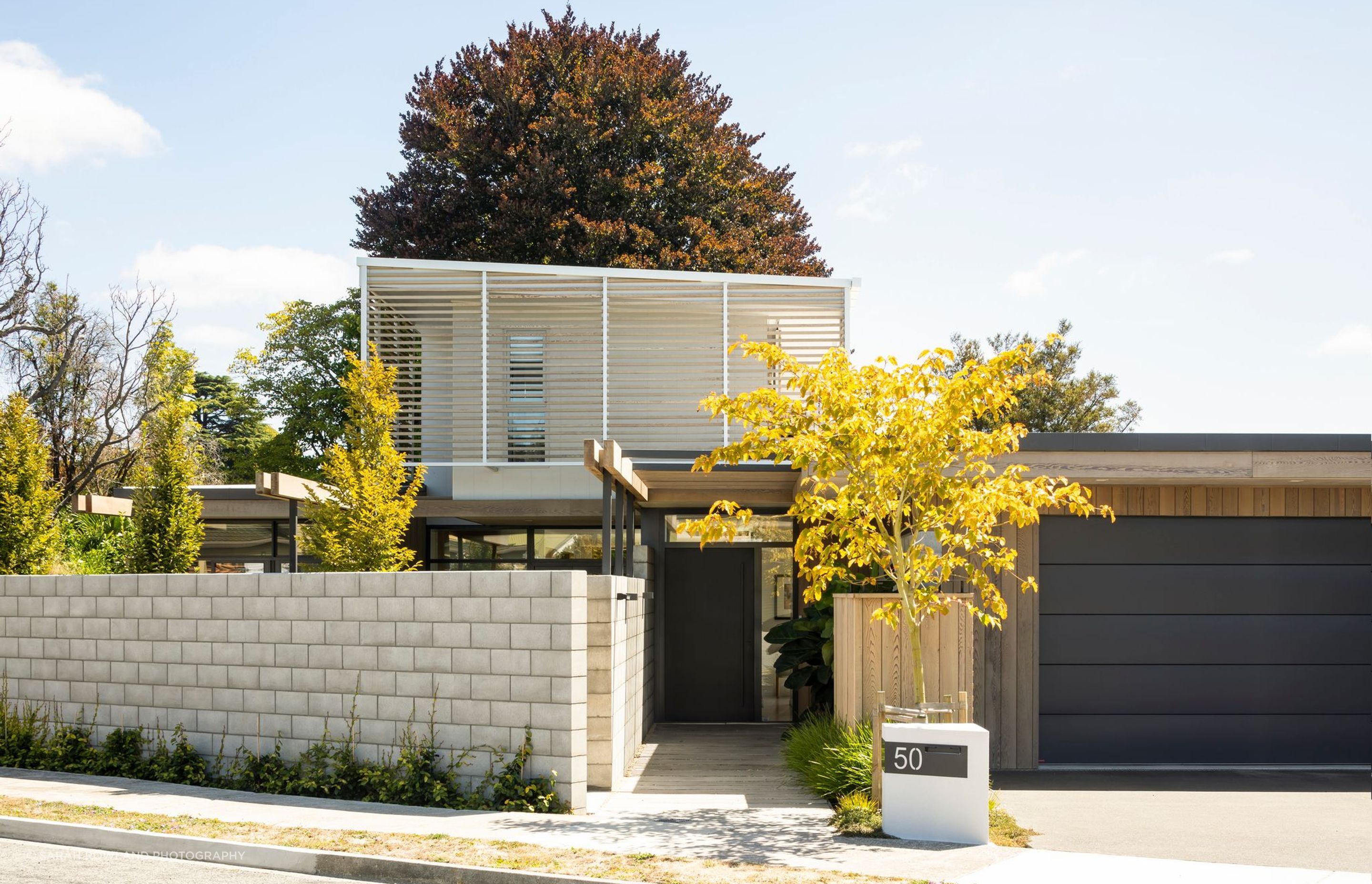 Accentuated by its light colour and cedar sunscreens within a skeletal steel structure, the upper level of this house has been designed to appear to be a ‘floating pavilion’.