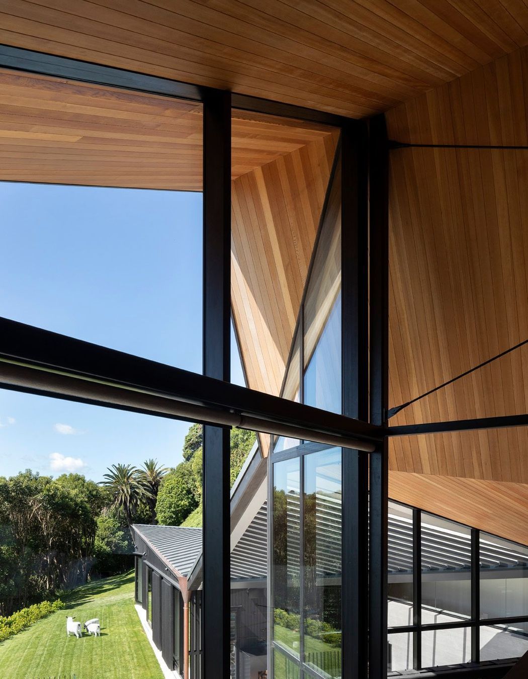 From the mezzanine main bedroom, the roof form is a big gesture, in the scale of the cliff, embracing the house and defined by the folds of the faceted ceiling.