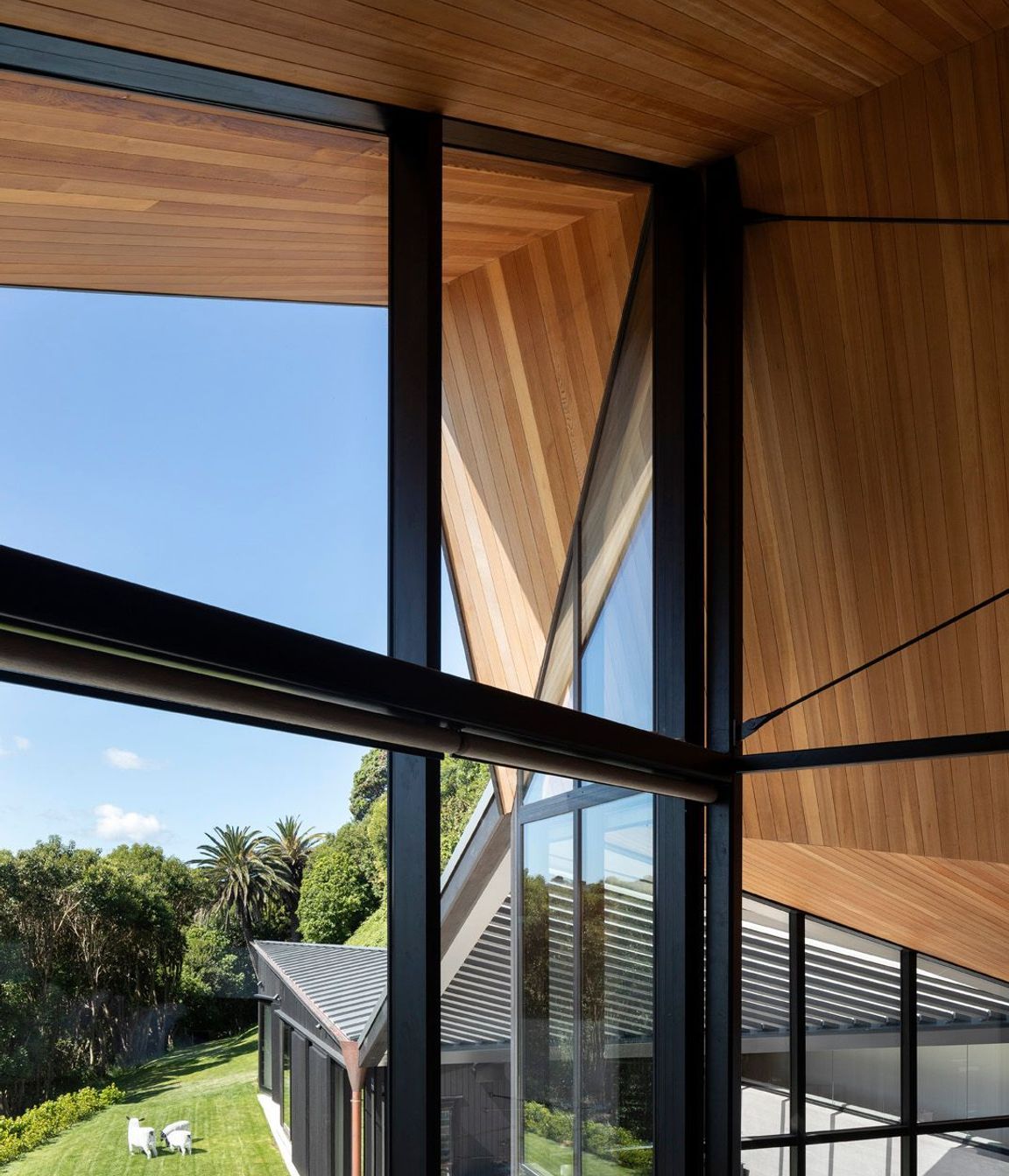 From the mezzanine main bedroom, the roof form is a big gesture, in the scale of the cliff, embracing the house and defined by the folds of the faceted ceiling.