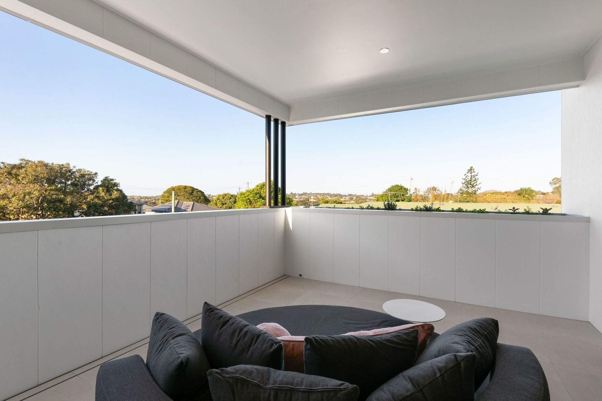 The upper balcony is a quiet corner, screened and open to the treetops.