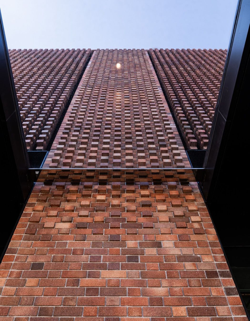 Brick louvers, or hit and miss columns of brickwork, alternate with the Brick Inlay panels, allowing 50% of the facade to be ventilated