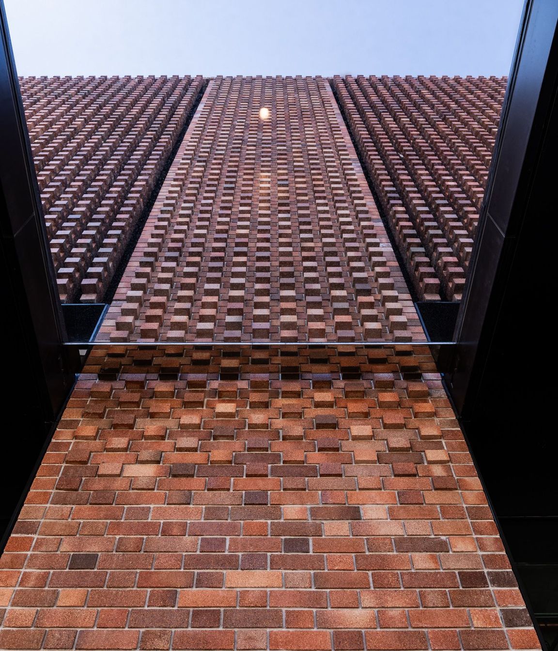 Brick louvers, or hit and miss columns of brickwork, alternate with the Brick Inlay panels, allowing 50% of the facade to be ventilated