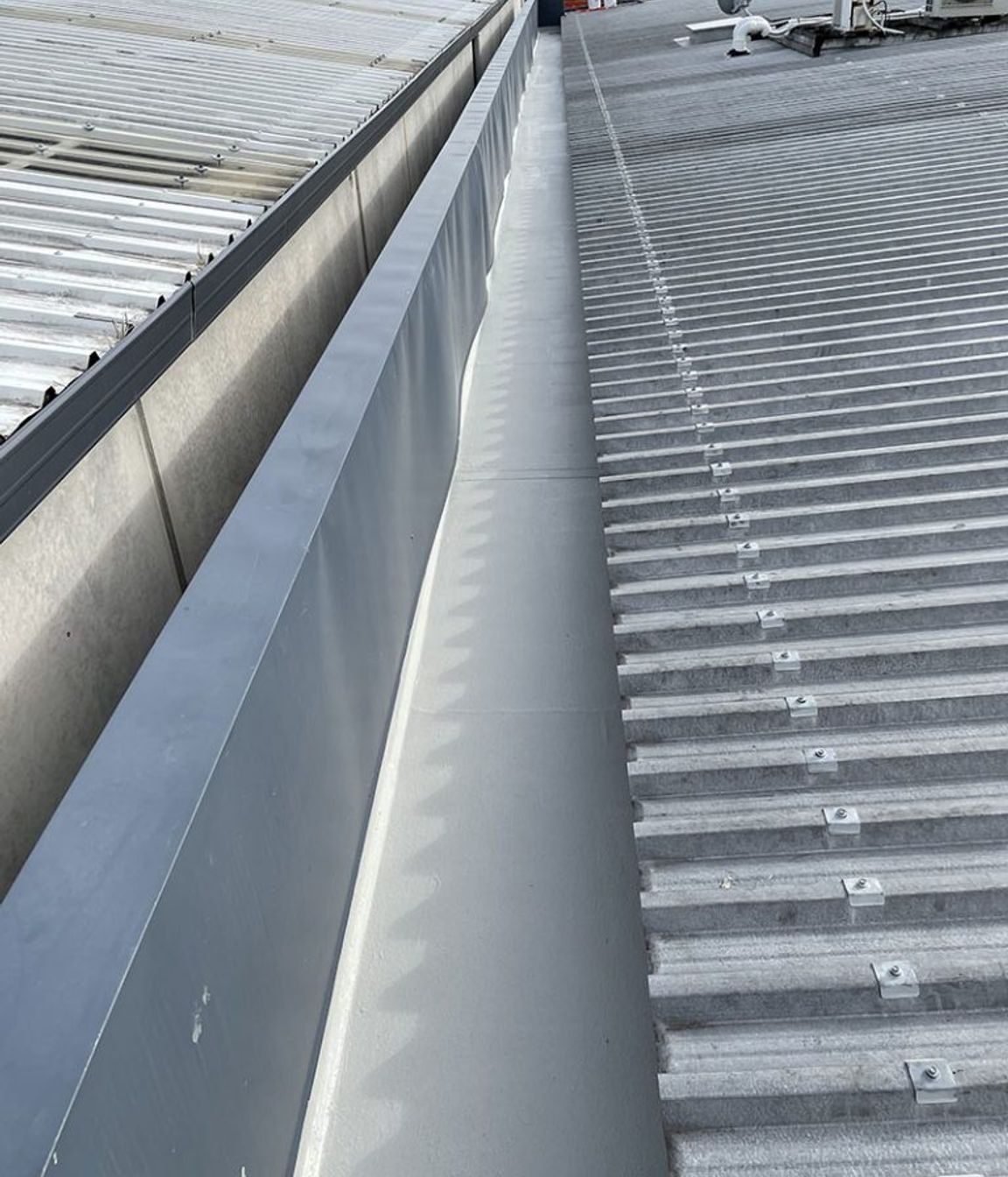 Liquid membrane system applied over existing membrane to internal box gutter