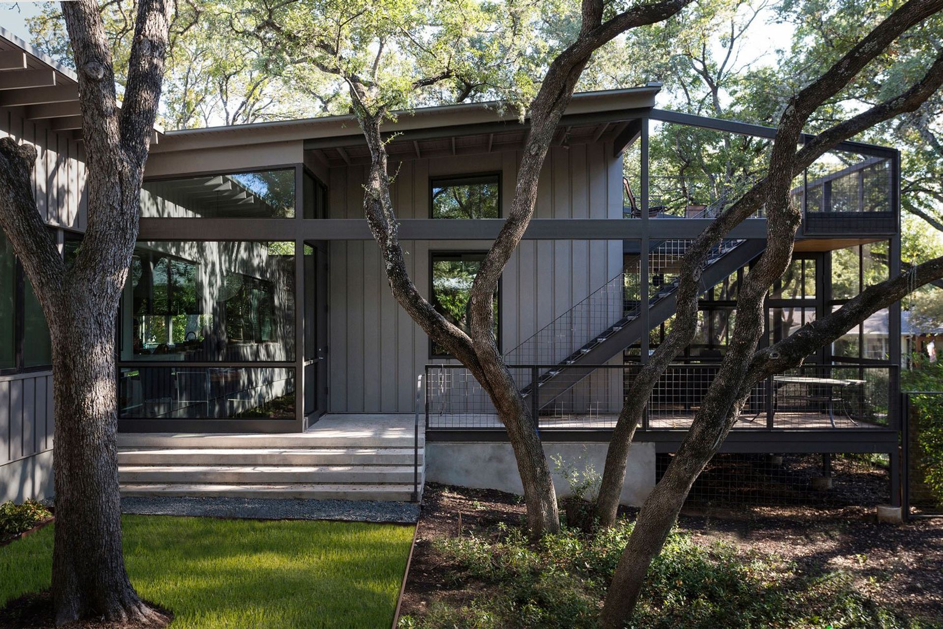 11RiverRoadCuppettKilpatrickArchitectureandInteriorDesignaustin-tx-backyard-view-modern-home-large-glass-panels-deck-staircase.jpg