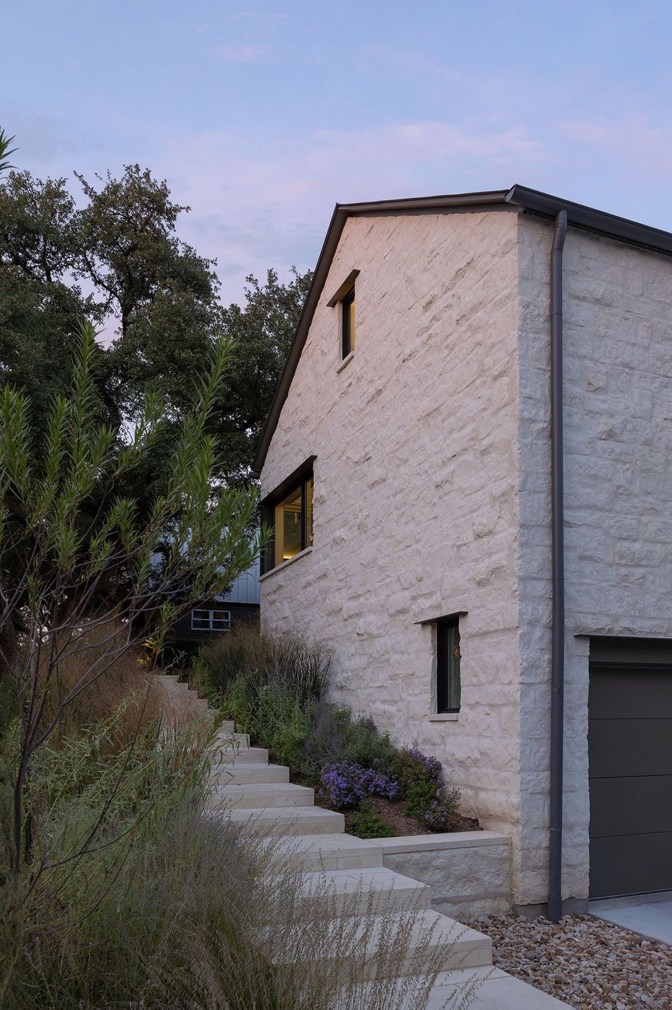 2RollingWoodCuppettKilpatrickArchitectureandInteriorDesignmodern-home-exterior-dusk-view-limestone-walls-landscaping-austin.jpg