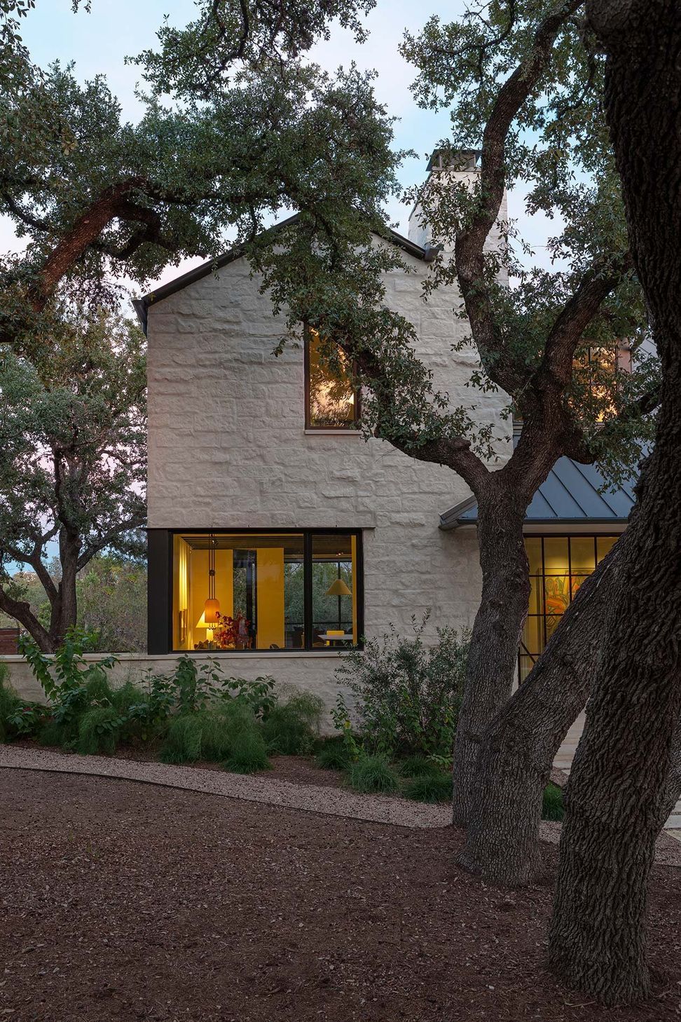 3RollingWoodCuppettKilpatrickArchitectureandInteriorDesignmodern-austin-home-limestone-exterior-evening-oak-trees-1.jpg