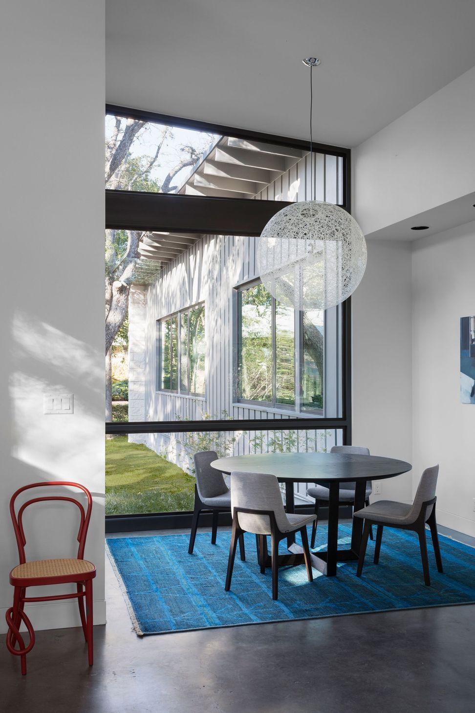 8RiverRoadCuppettKilpatrickArchitectureandInteriorDesignaustin-tx-dining-area-design-large-windows-red-chair.jpg