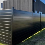 Black Horizontal Slat Solid boundary fence around architectural resdiential home with mountain in background