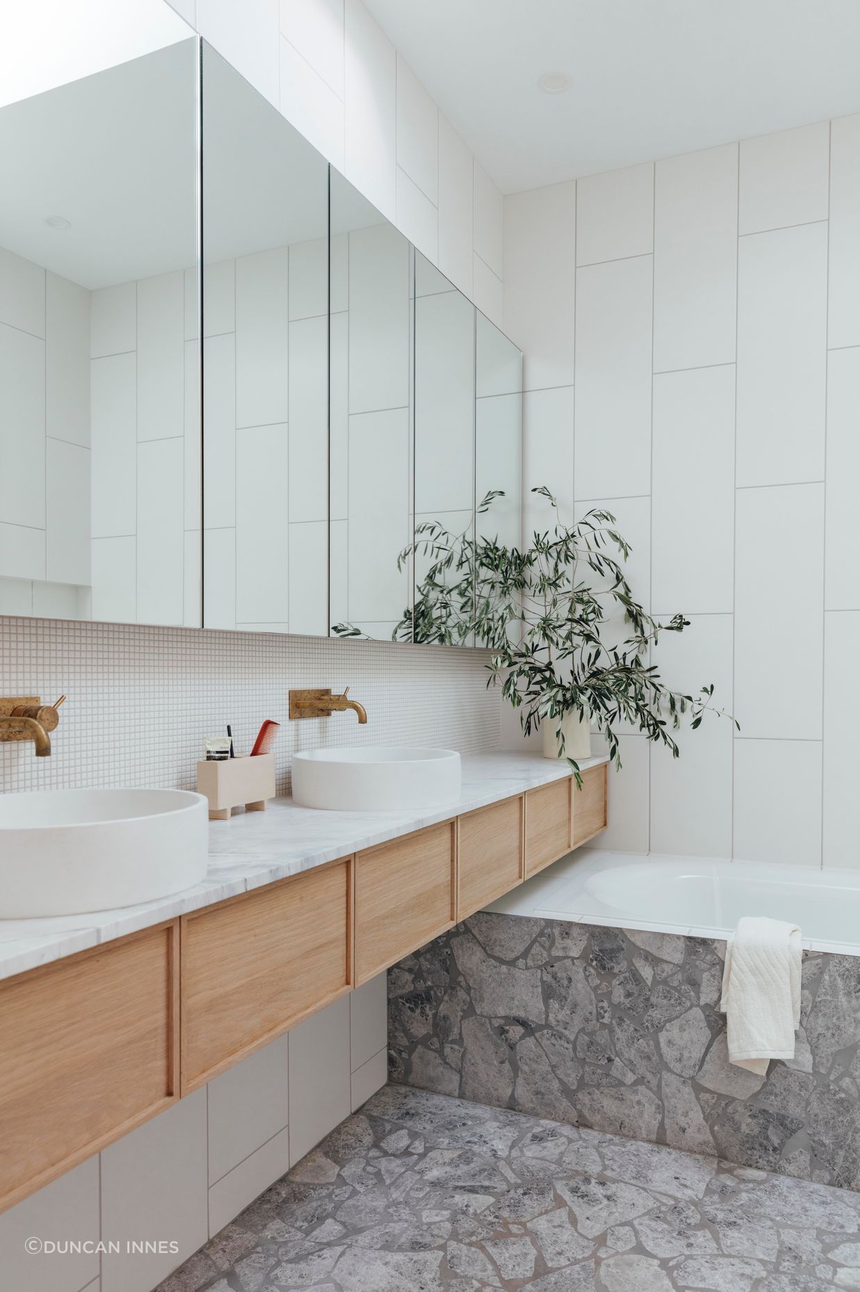 An ensuite uses a light, fresh material palette.
