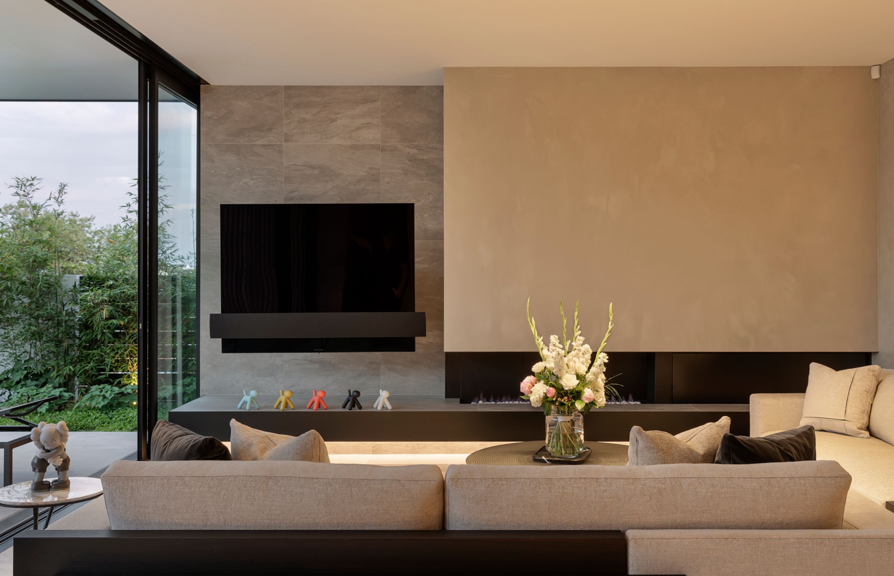 The lounge is a cleverly curated modernist composition of fireplace, large-scale television, sofas and coffee table.