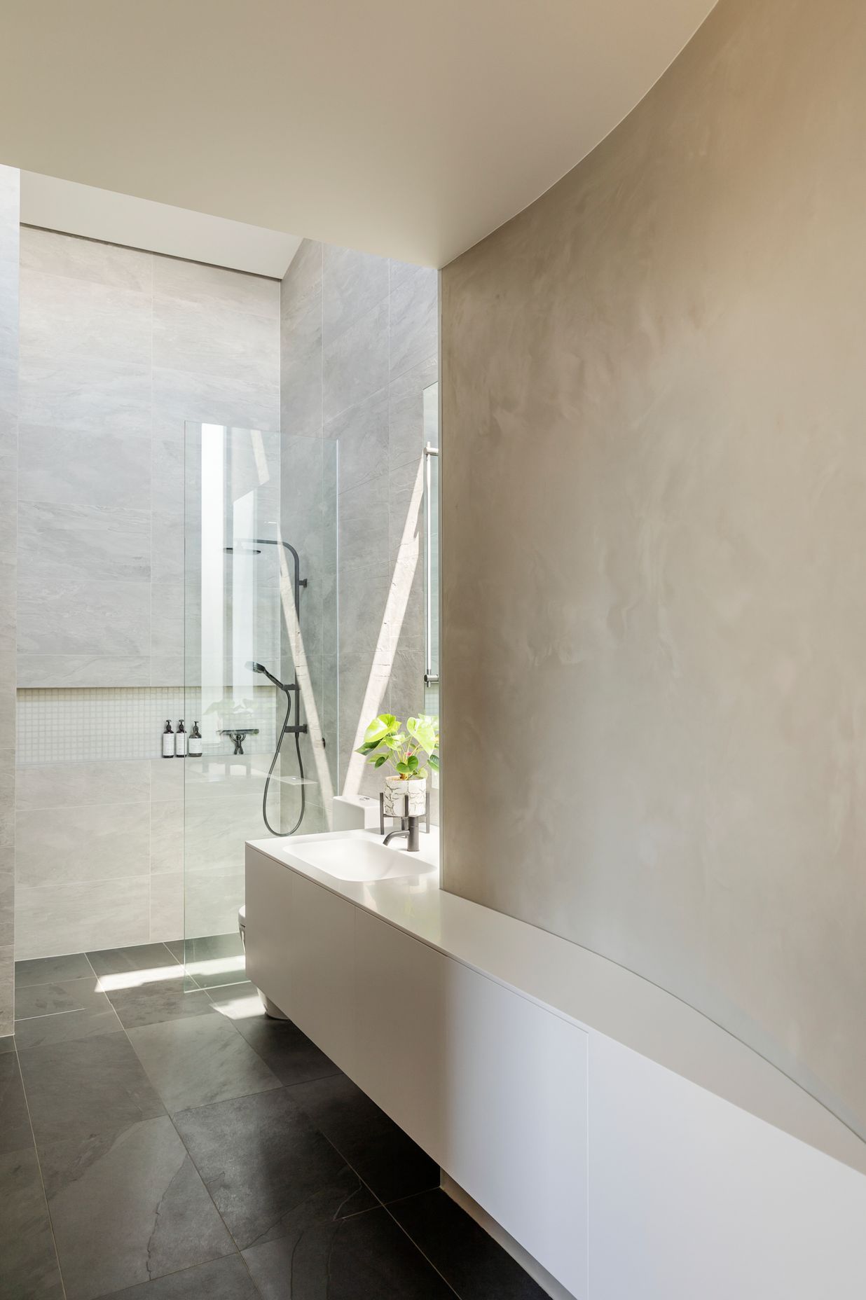 The ensuite bathroom maximises the internal curves formed by the curved garage walls.