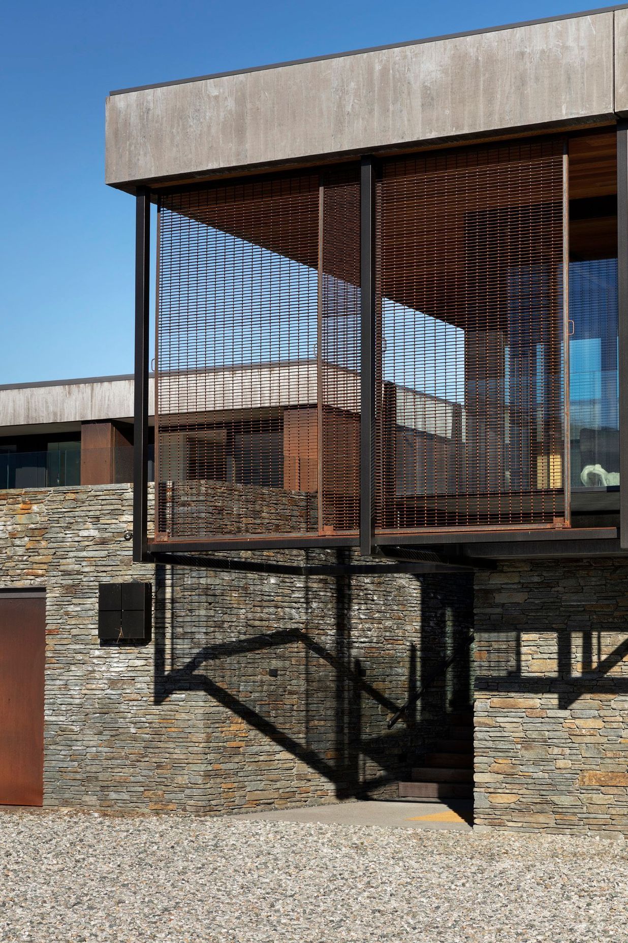 Rusty steel caging and schist stone take inspiration from buildings fo the region.