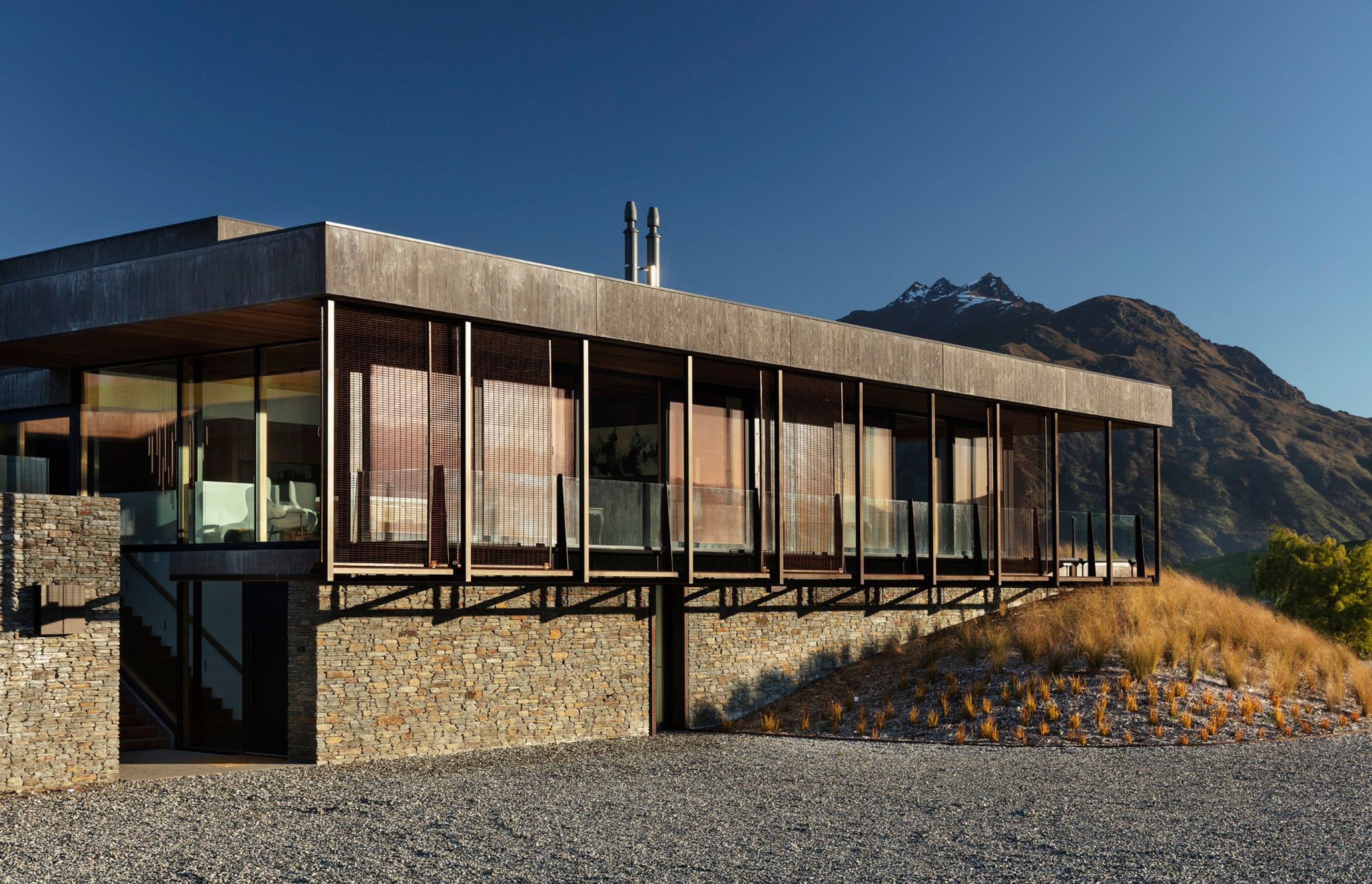 An exterior in natural schist stone, Corten steel and concrete helps to blend Oliver's RIdge into the surrounding landscape.