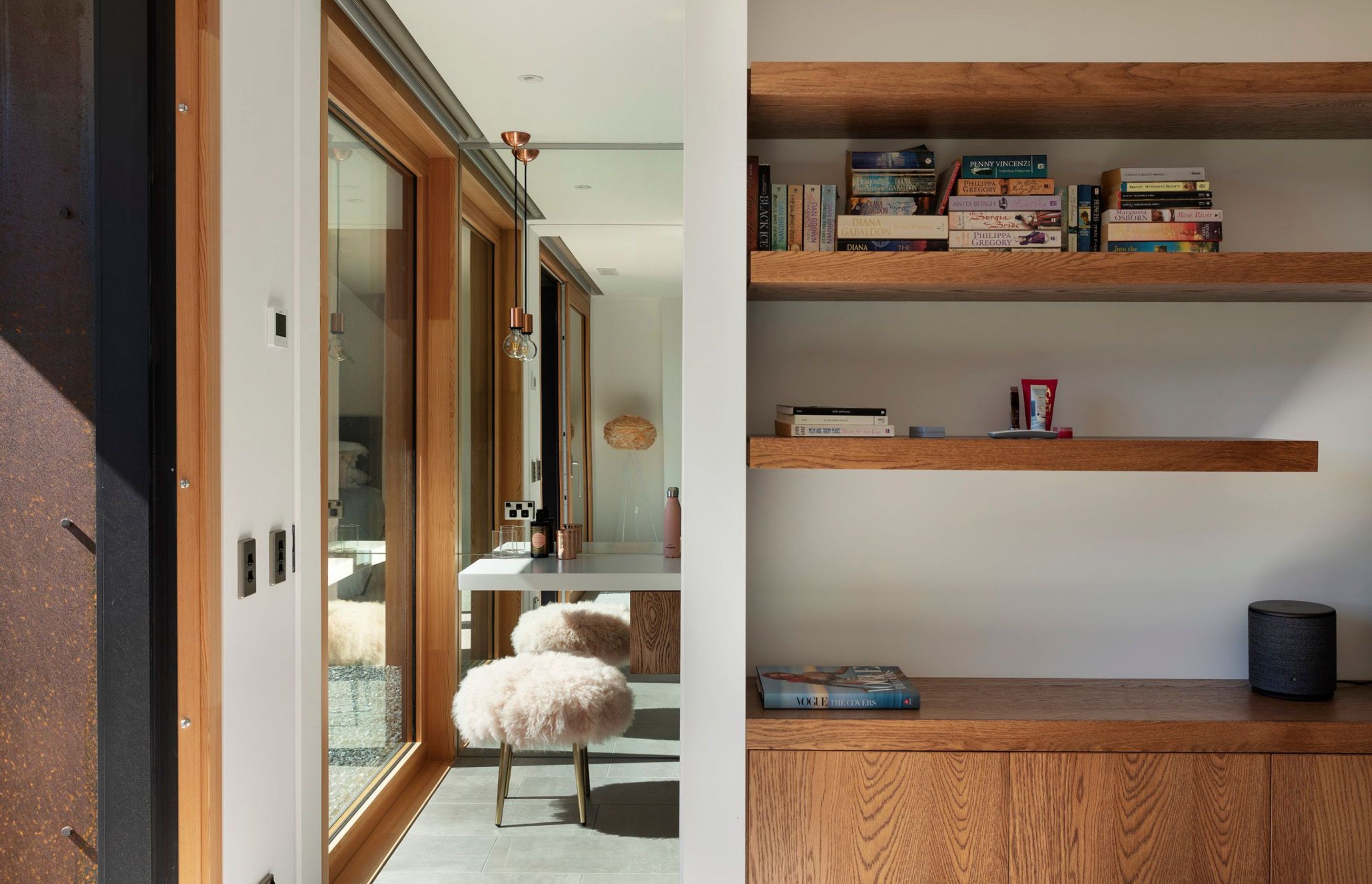 Oak shelving and oak cabinets divides this first-floor bedroom from its en suite bathroom.