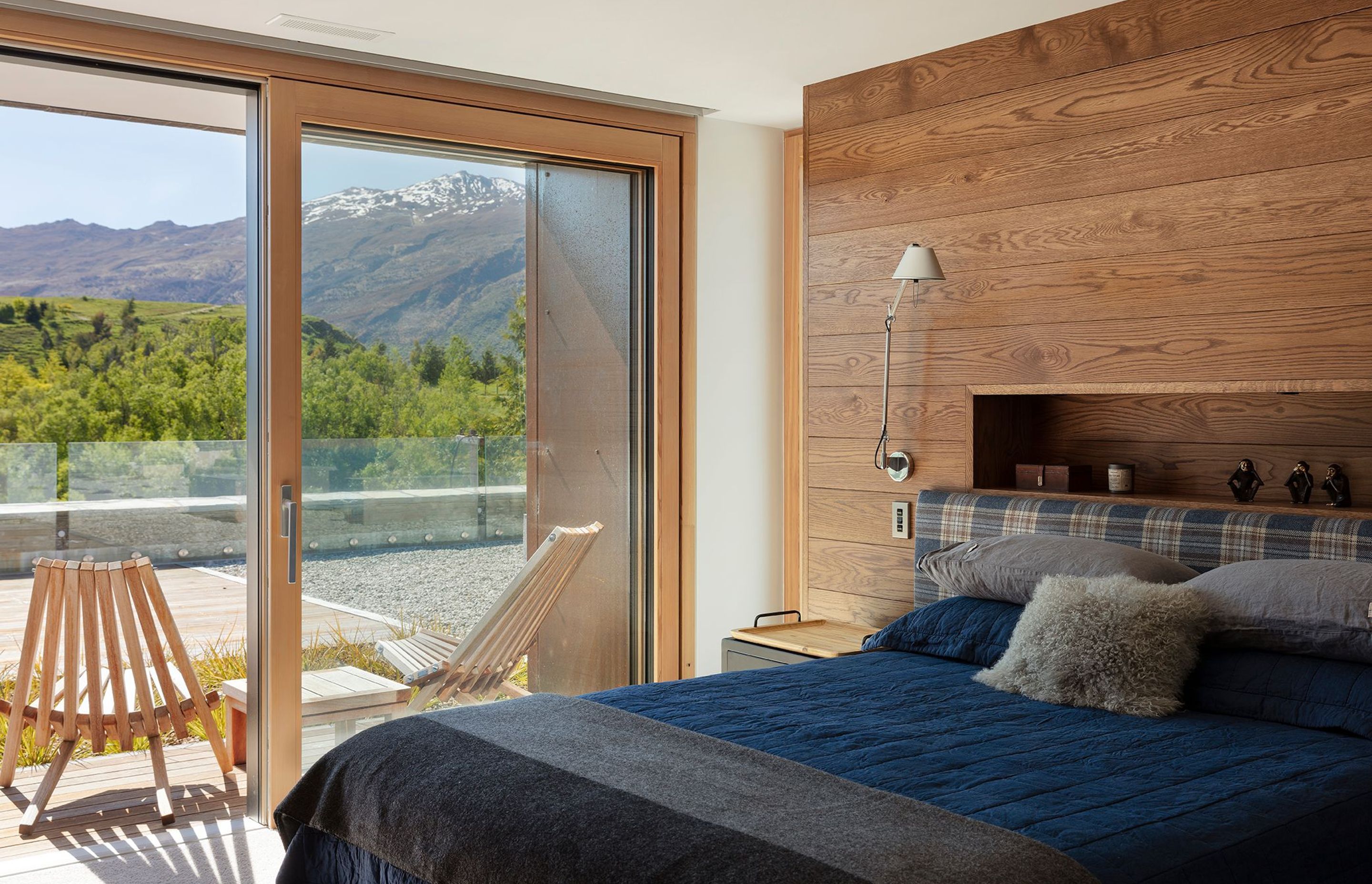 One of the first-floor bedrooms enjoys mountain views, a custom-made oak-panel and tartan fabric bedhead and access to an outdoor courtyard..