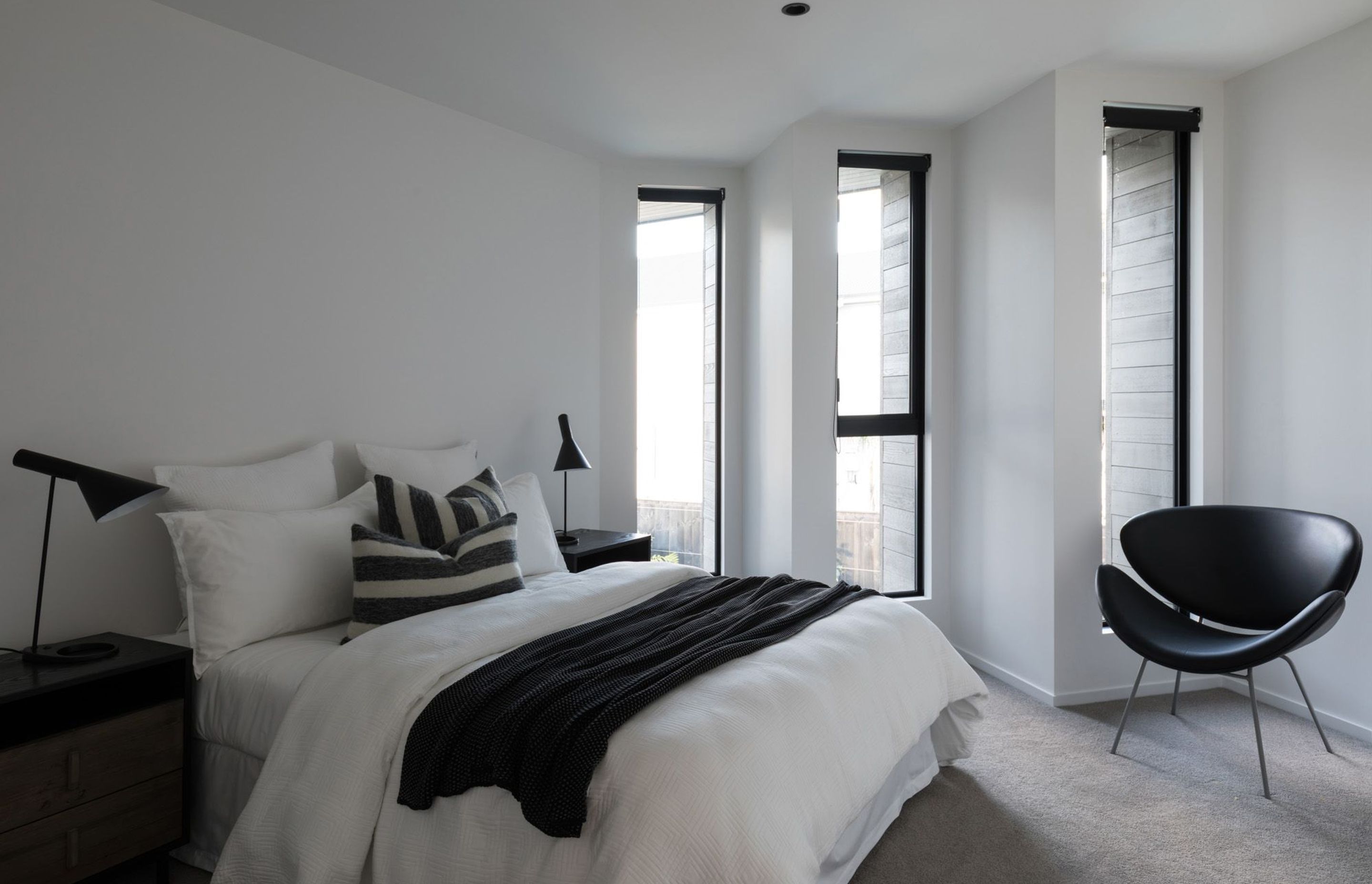 The black-and-white colour scheme continues throughout the interior of Takapuna House, seen here in one of the bedrooms.