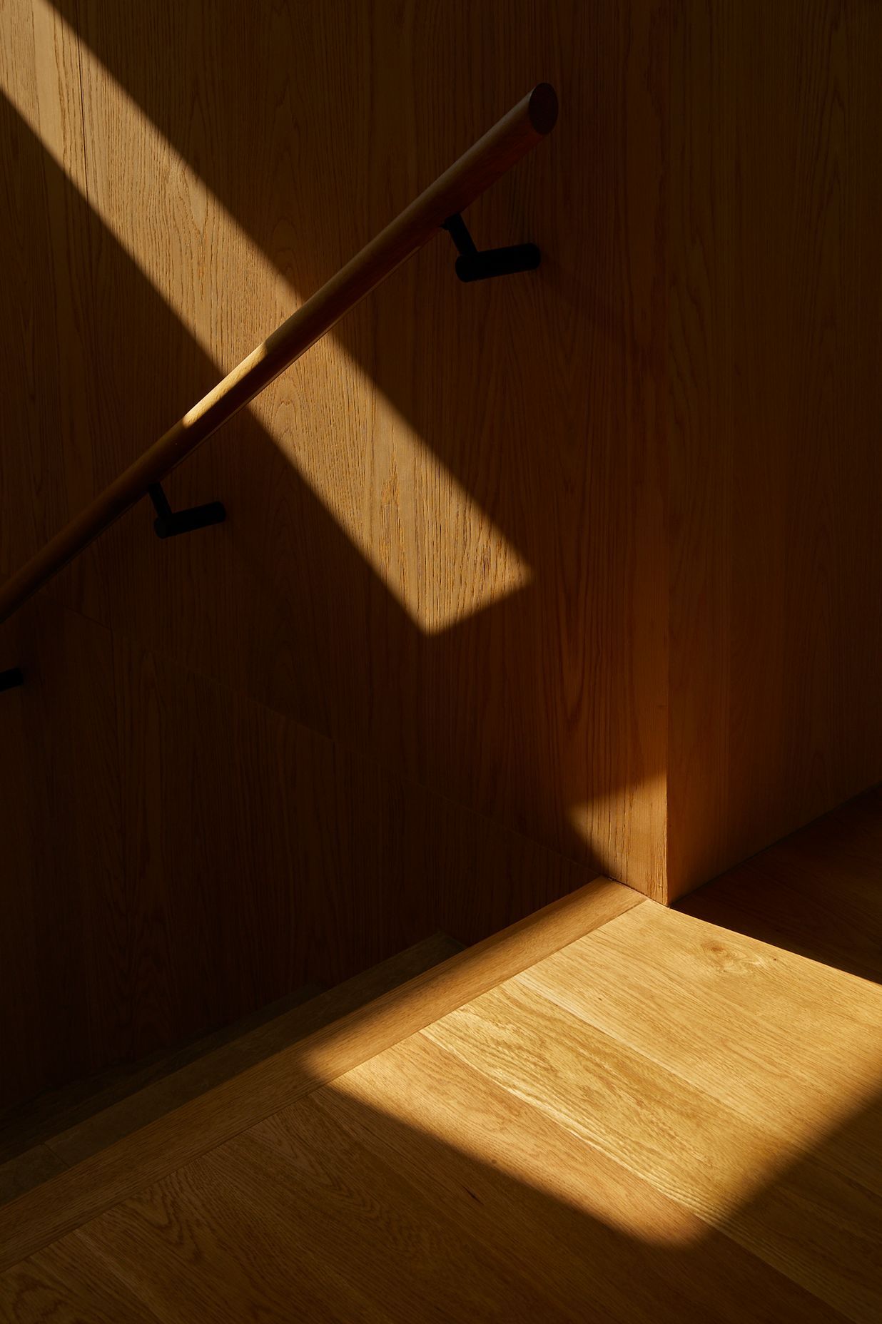 American oak lines the stairwell, adding a warm contrast to the concrete details.
