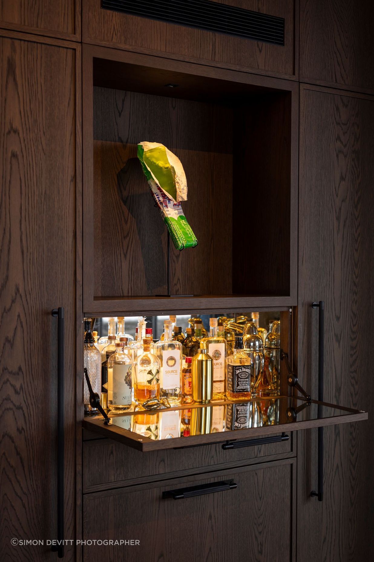 A mini-bar concealed in the kitchen cabinetry. The homeowners are art collectors - the K Bar sculpture is by Simon Lewis Wards.